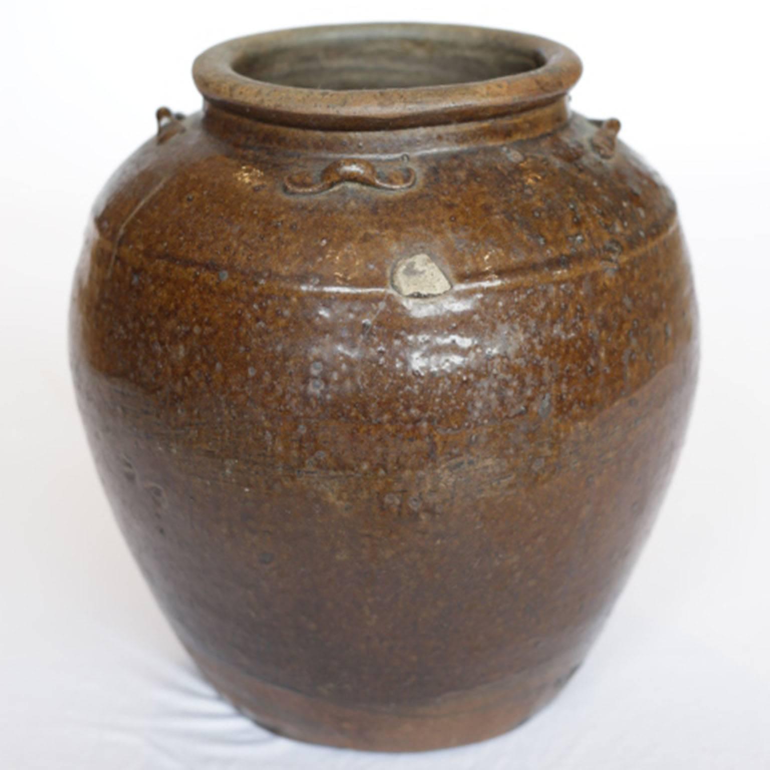 Glazed brown storage jar, South East Asia, with four ceramic 