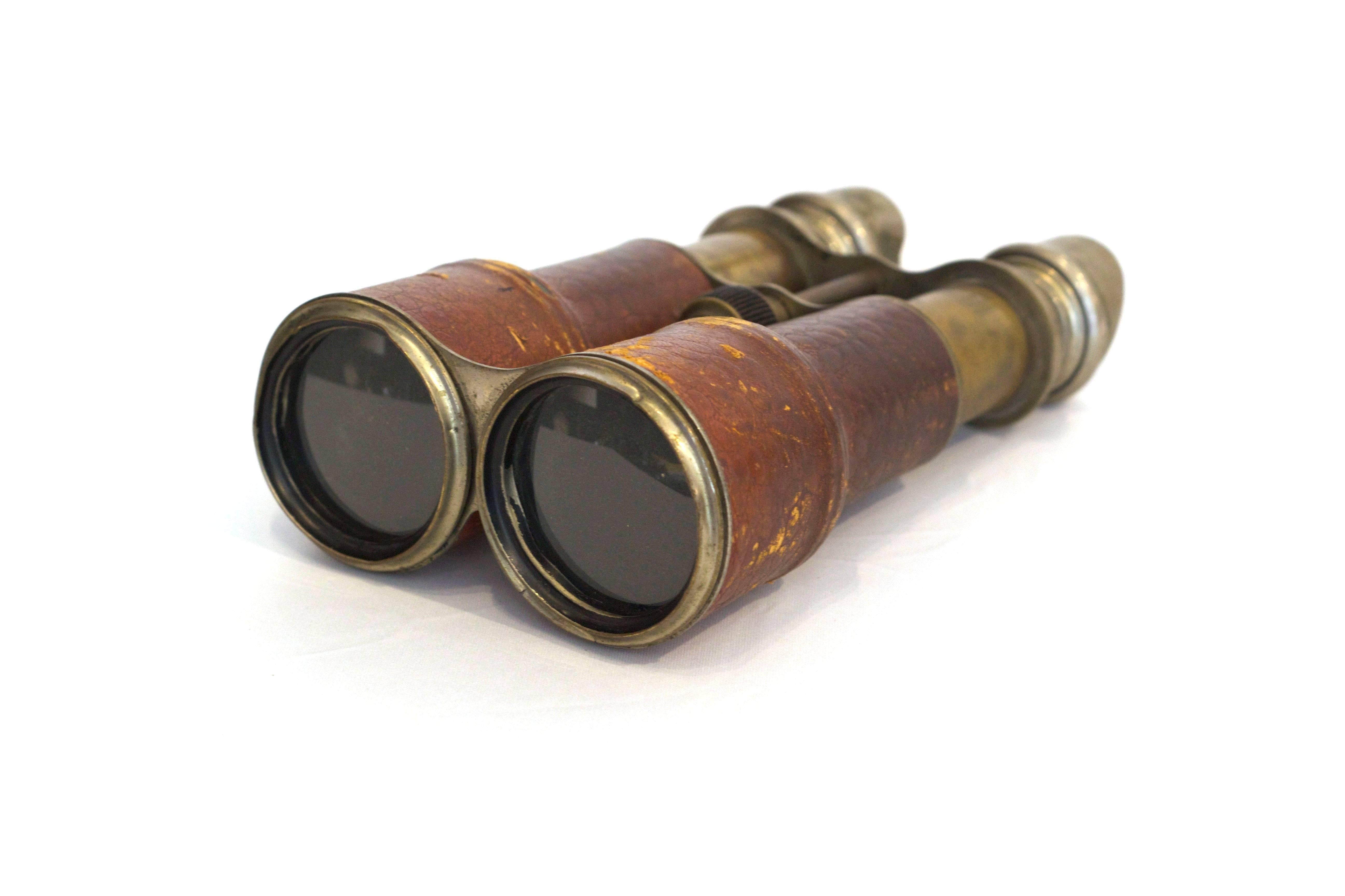 Expandable brass binoculars wrapped in tobacco colored leather. Stamped 