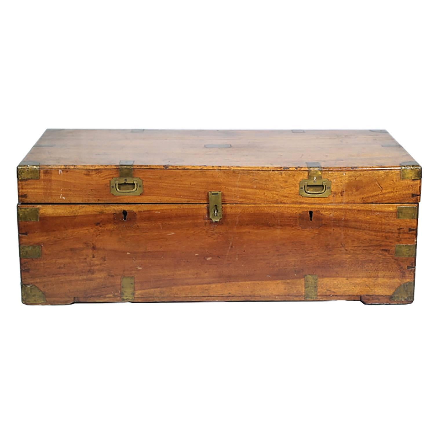 Pre-1820 walnut trunk with two brass handles in front and metal handles on the side. Corner and edge brass detailing throughout the trunk. Interior has been relined with cedar. 