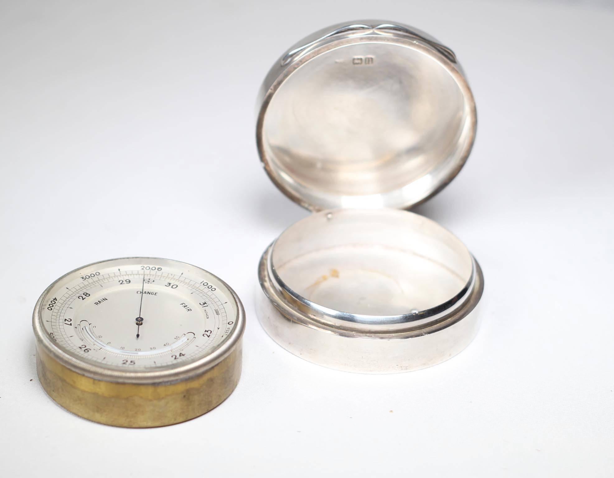 Victorian brass aneroid pocket barometer with altimeter scale, circa 1830-1890, 
in a later Edwardian sterling case with hallmarks for London, 1908.

Barometer features dial that points to 