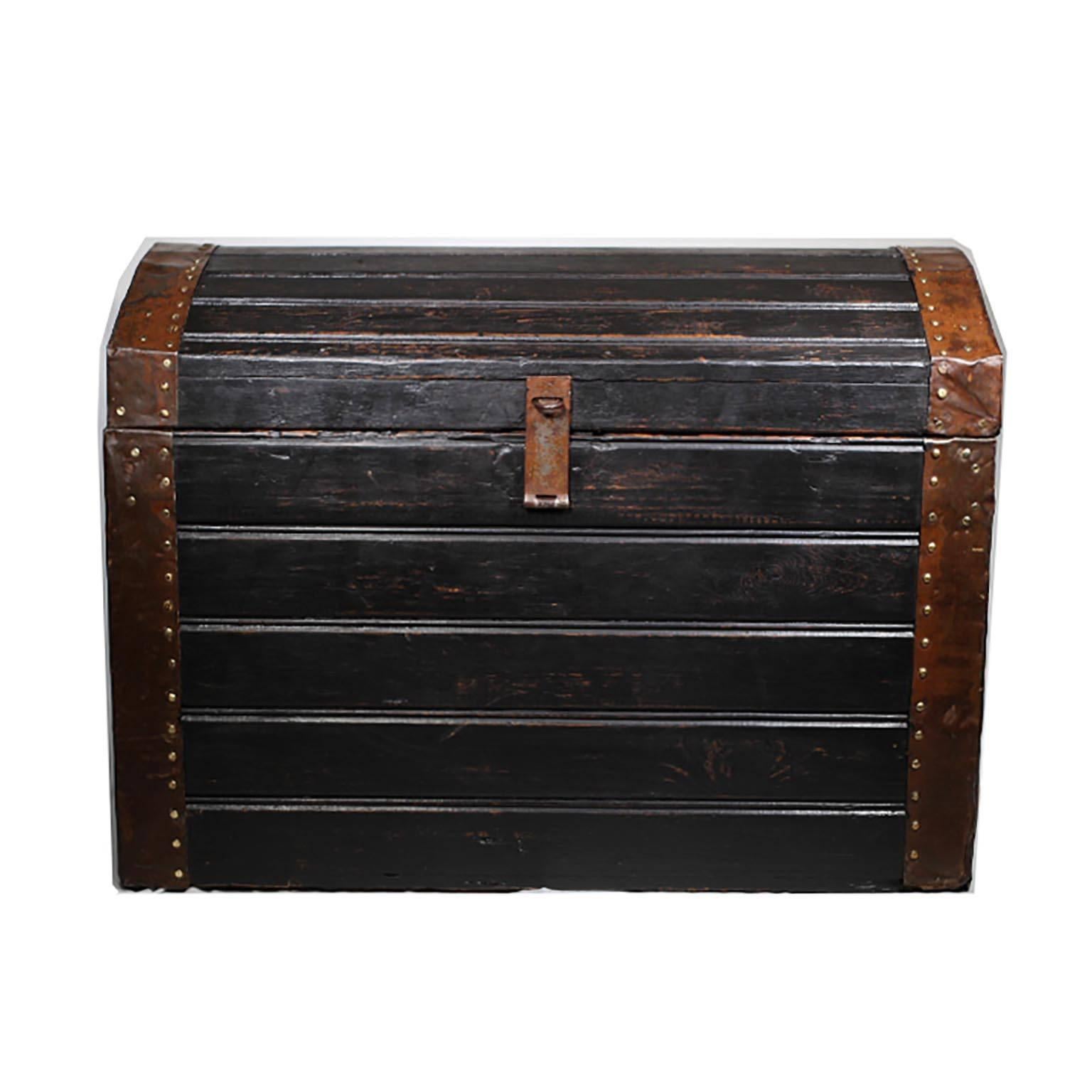 Black wooden trunk with copper plated metal bands wrapped around the edges. Original label on the side date 1907. Possibly Swedish.