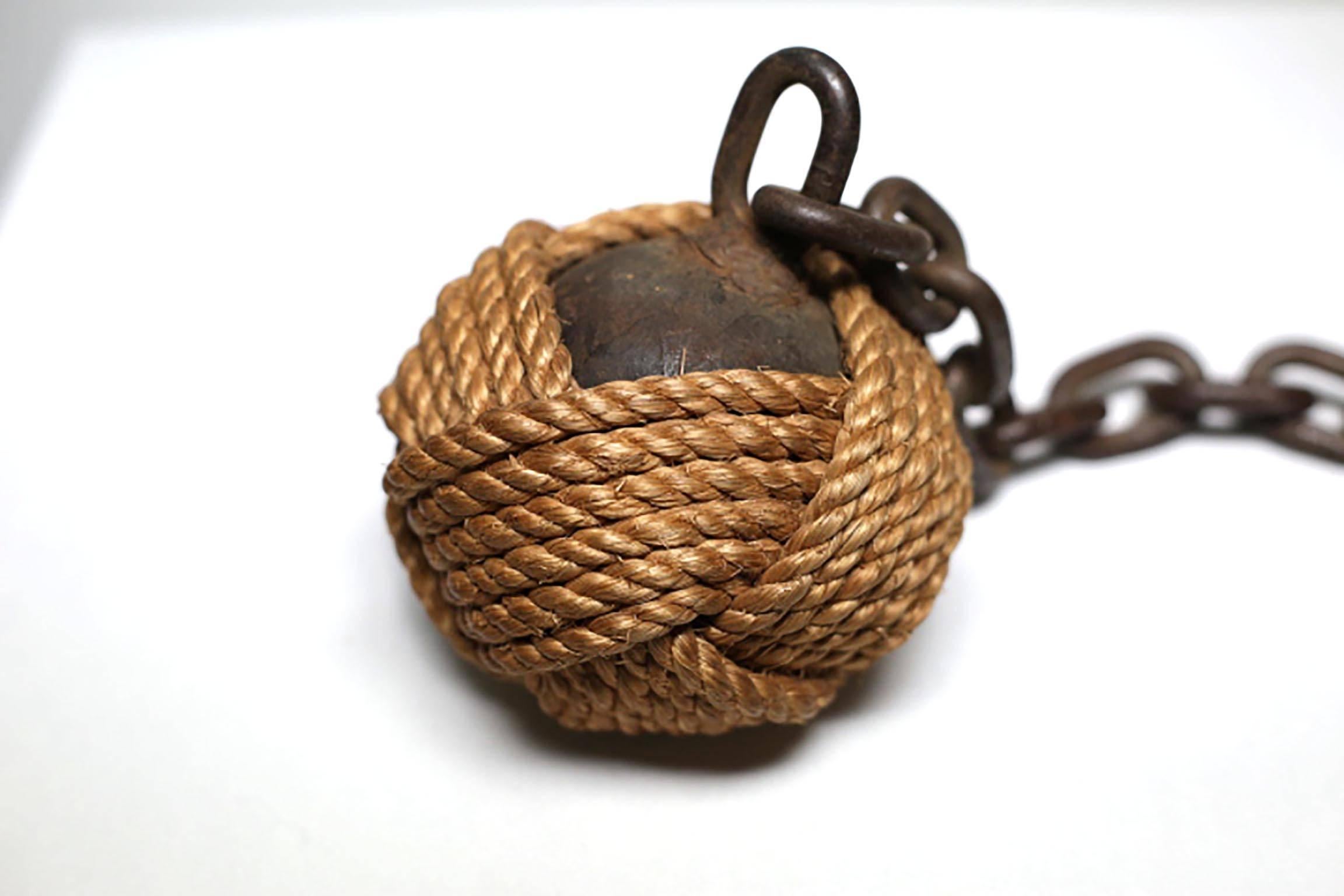 Cast iron ball and chain used by prison guards to control prisoners. Rope probably added later. Possibly earlier than the 19th century.