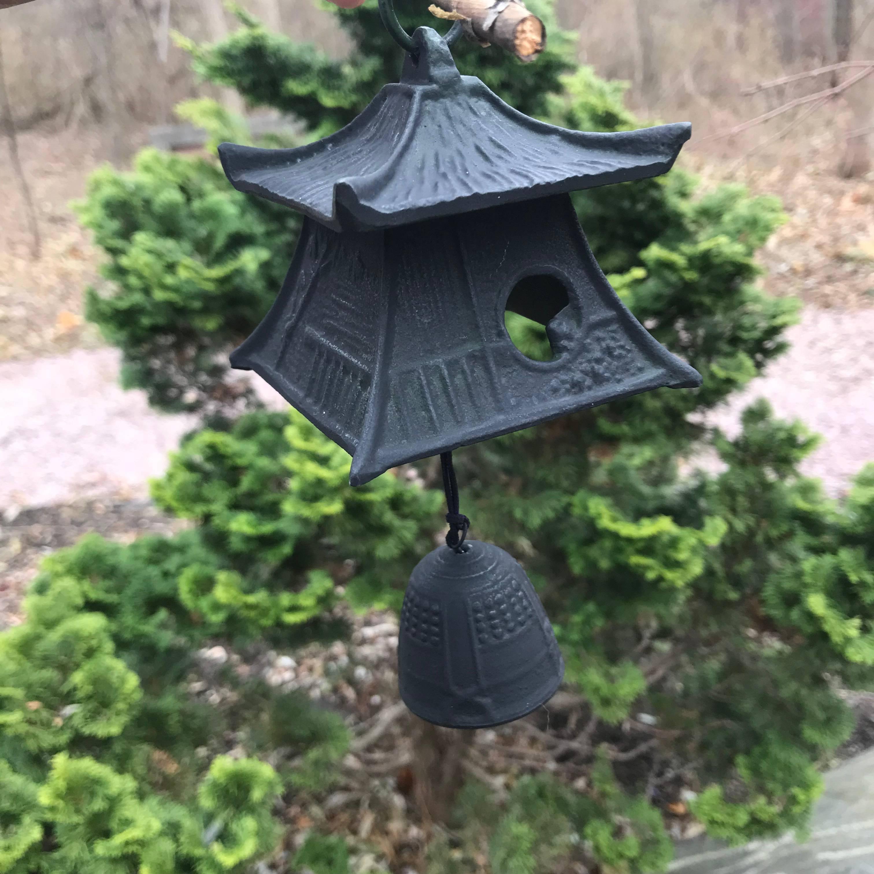 Japan, an unusual handcrafted bronze ringing lantern or wind chime in the form of a Japanese mountain minka farm house that may be suspended in your favourite indoor or outdoor space. It is accompanied by a solid iron hanger featuring a monkey.