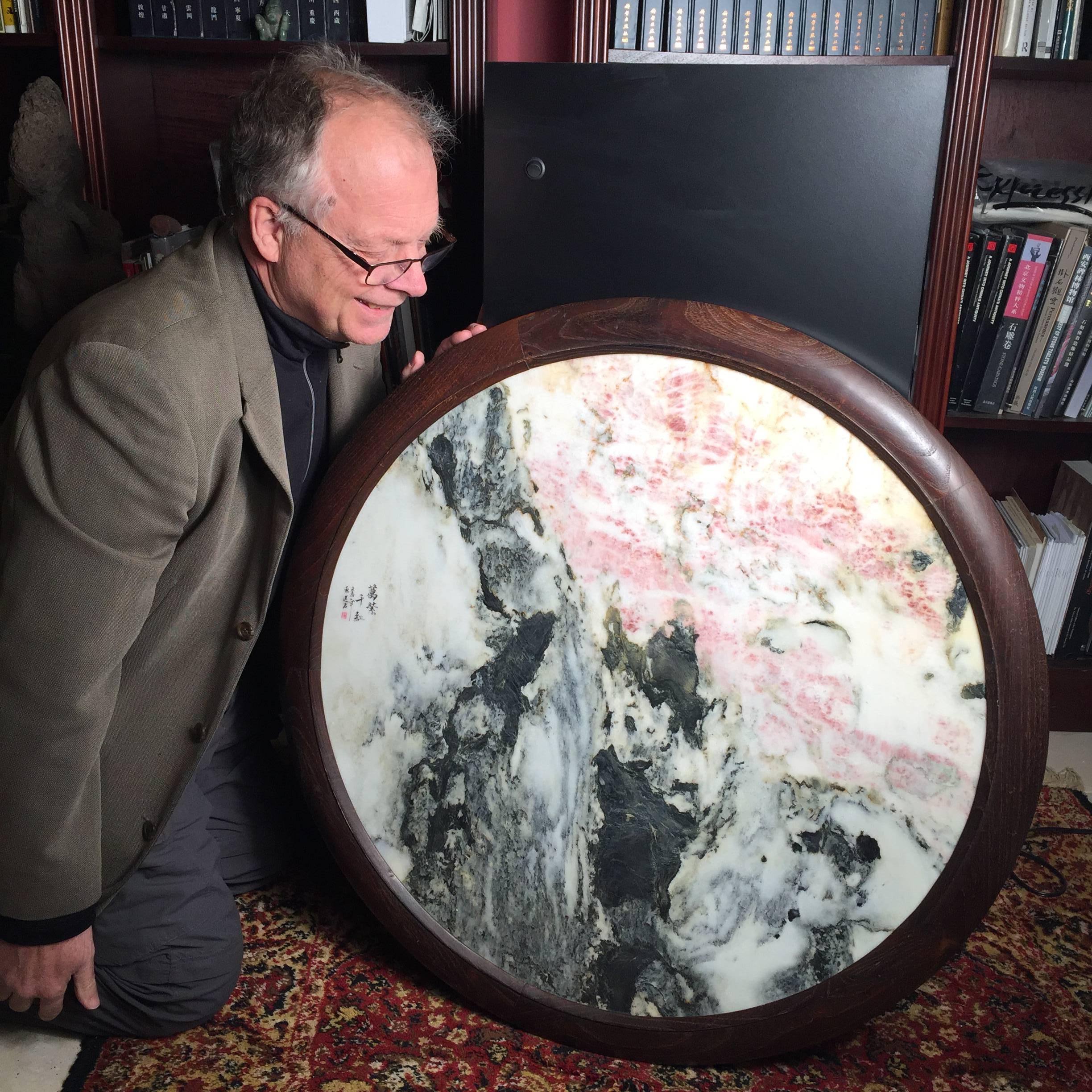 This Chinese large round and extraordinary natural stone painting - a masterwork-  in large scale moon gate form features mountains, pink and white clouds, and abstract images of two friends meeting in the center.  

Indeed the artistic calligraphy