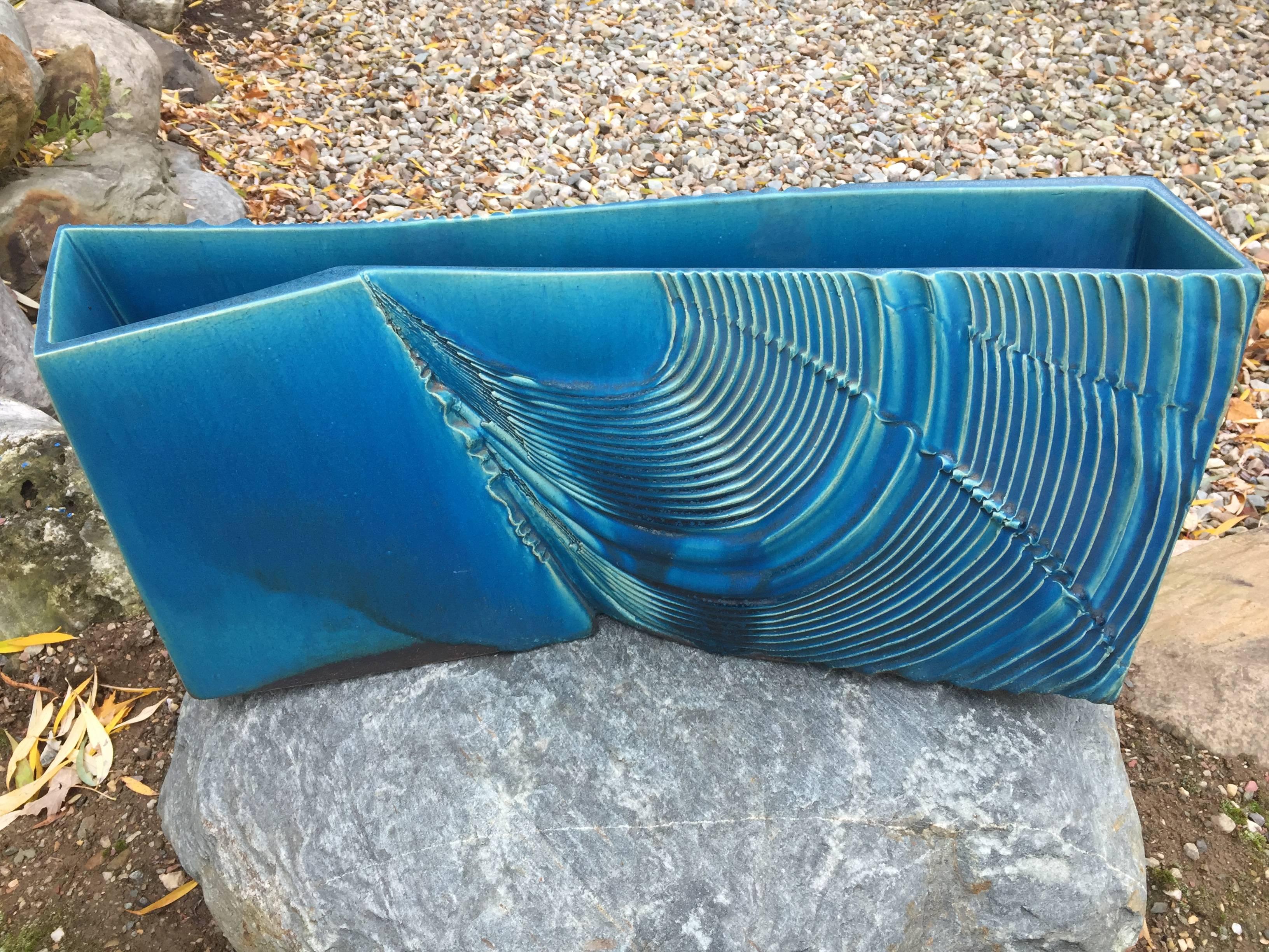 Mint, Signed and Boxed

A superb large-scale Japanese ikebana planter crafted in a beautiful blue glazed ceramic swirling wave pattern. 

It is signed and likely one-of-a-kind..

Included is the original signed collector storage box tomobako.

Hand