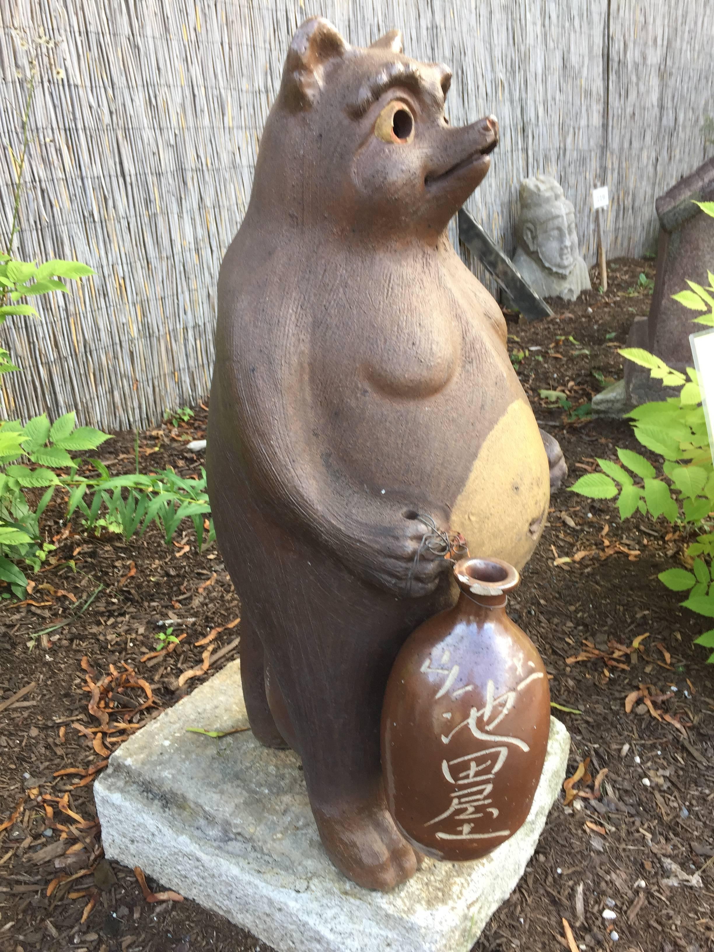 An old, large-scale, and big bellied Folk art Hero Tanuki- raccoon dog party animal from Japan, glazed pottery.

Dimensions:  38 inches high

Quality: Fine quality and hecarries a 19th century sake pottery bottle which is included. Now hard to find