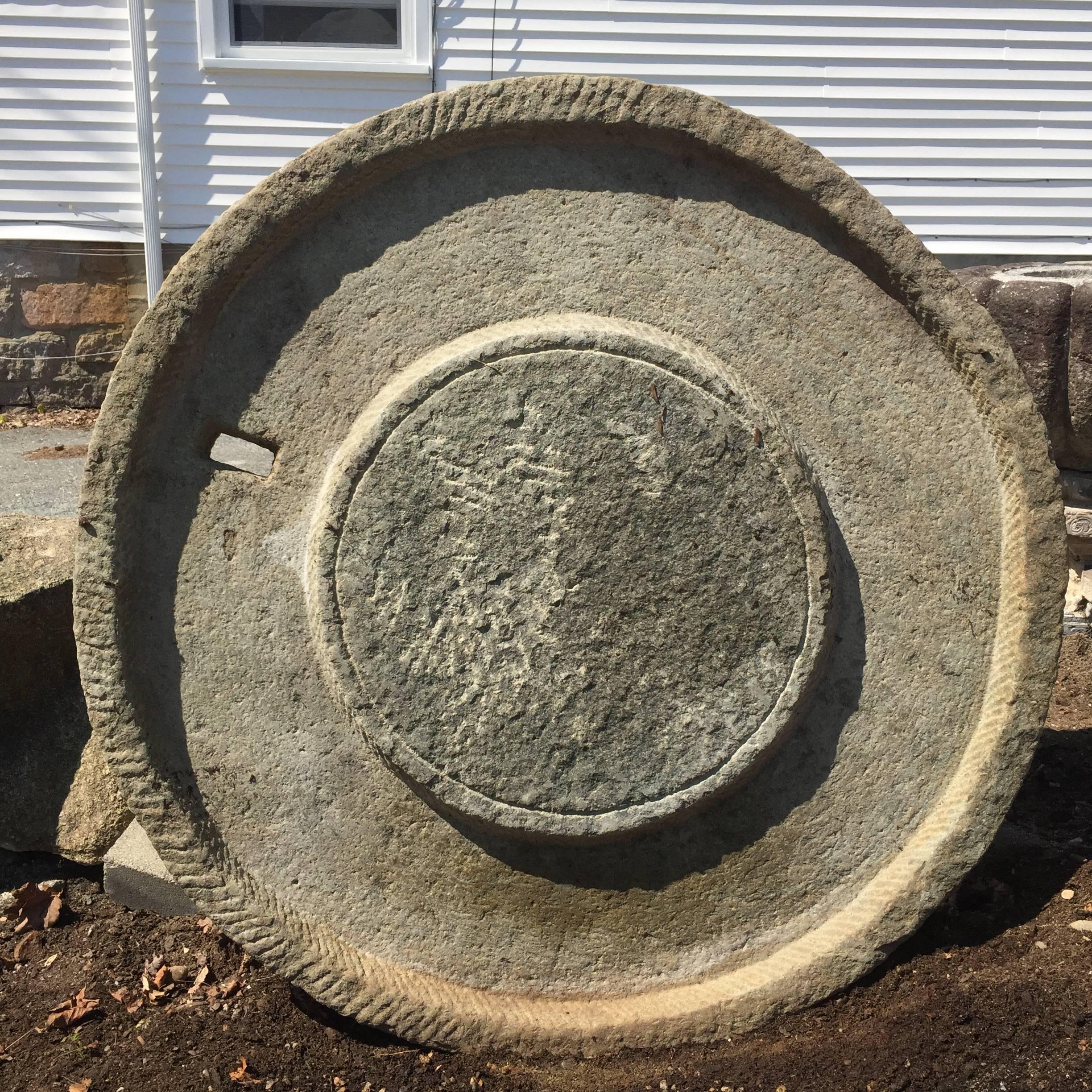 From China, comes this huge 46 inch diameter round hand carved mill stone from the 19th century or earlier period. This was likely a grinding base stone for a large oil pressing tool and device.

Dimensions:  46 inches diameter and 4 inches thick