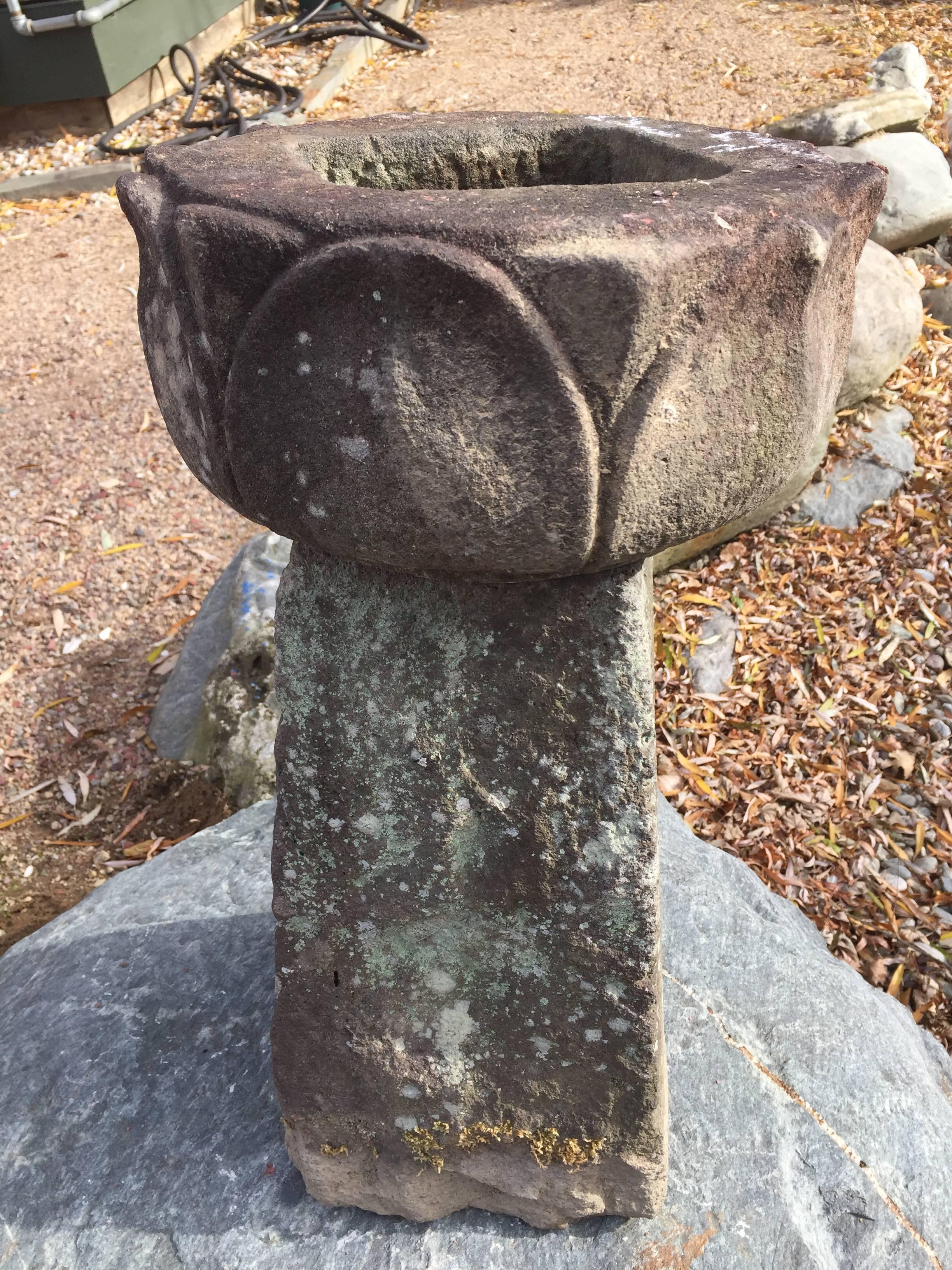 Japan, a handsome, ancient and hand-carved stone lotus bowl shape that balances beautifully a top a separate tapered pyramidal stone base. This ensemble exhibits substantial patina and lichen from great age. 

The bowl masterfully and delicately