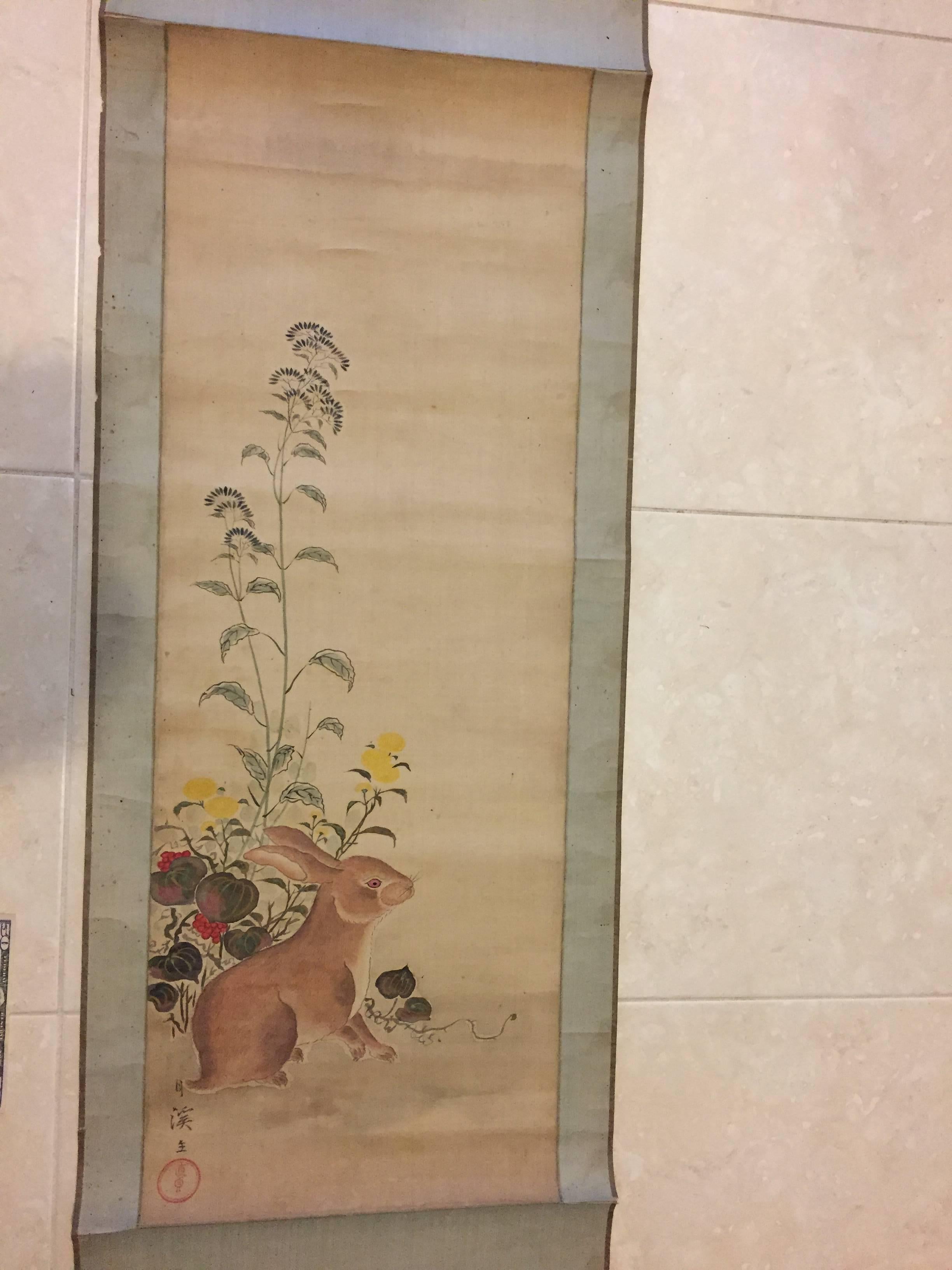 Japan, a scarce hand painting on paper scroll of a "Rabbit in Flowers" signed , old black rollers, Taisho/Showa period, (1912-1930s).

 Dimensions: 21 inches wide and 62 inches length.

Hard to find subject matter, this painting is
