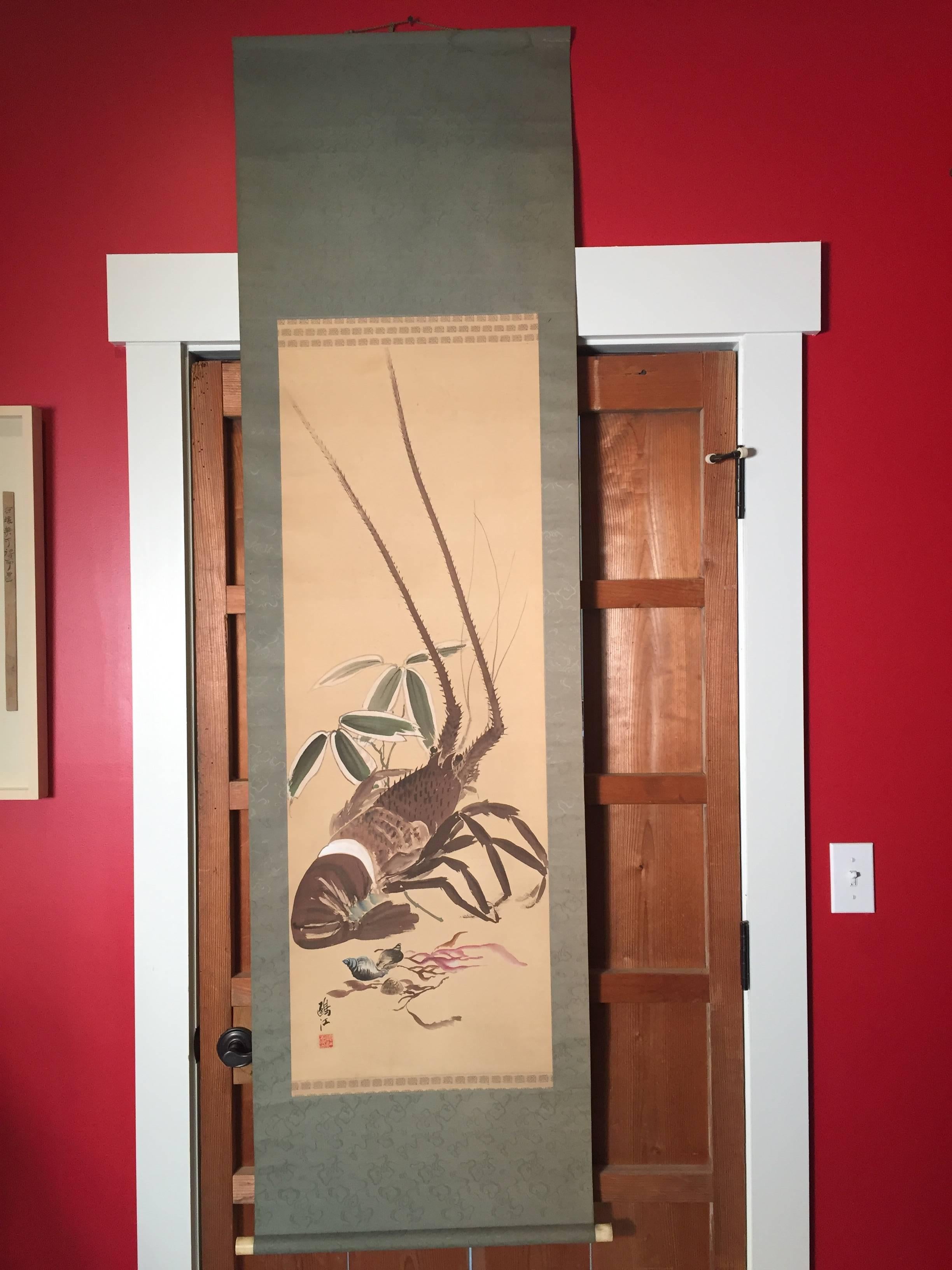 Japan, a large lobster glides the waters in this auspicious art declaration of this hand painted paper scroll dating to the 1940 early Showa era signed by Kikuchi Oko It's larger than life size graphicly under scores its significant presence and