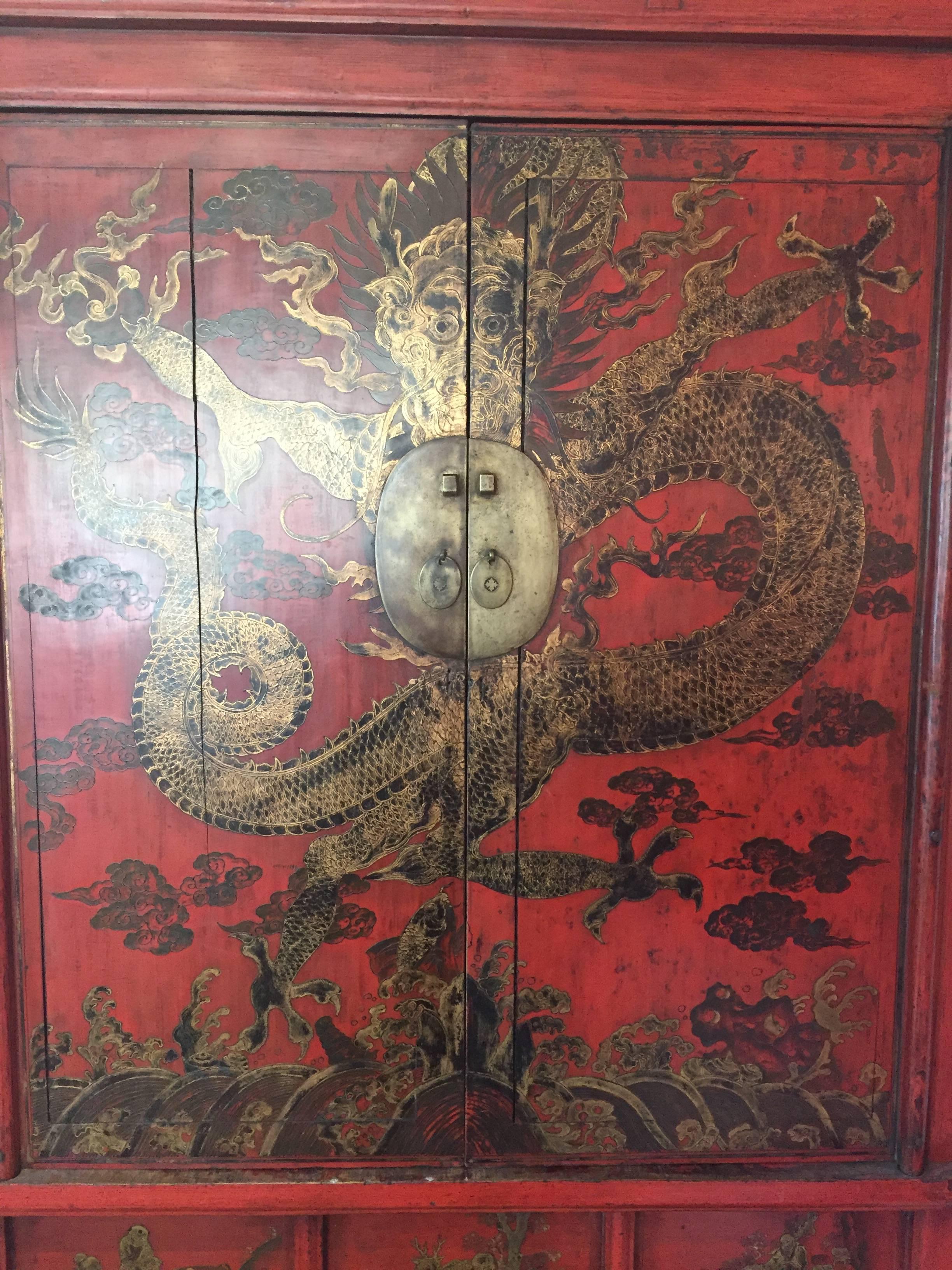 A fine tall Chinese antique dragon cabinet with prolific red lacquer and gold gilt details.

Dimensions: Exterior is 82 inches high and 51 inches wide and 21 inches deep. Interior Shelves are 18 inches deep and 49 inches wide. 
Distance between