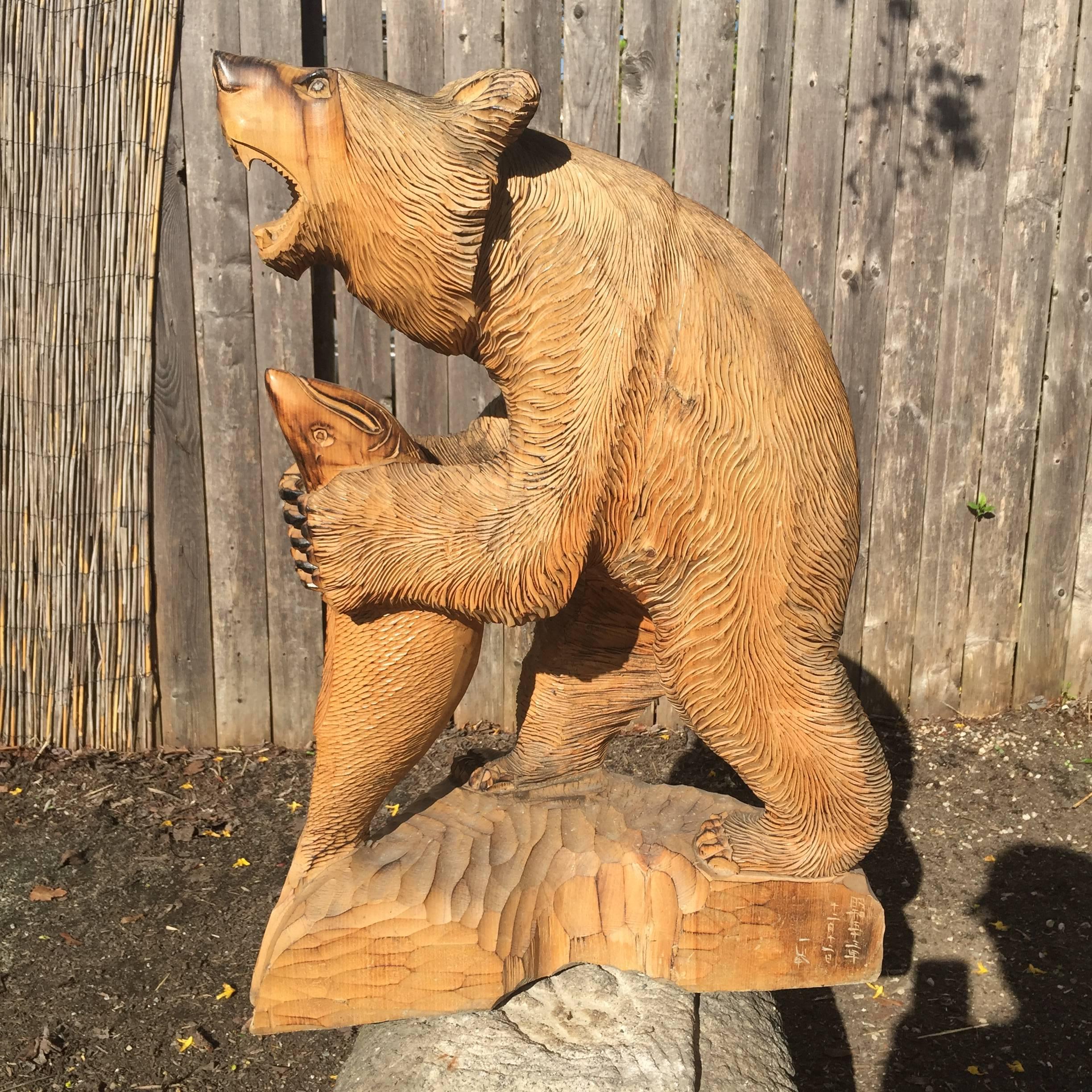 Japanese fine old handmade and hand-carved large-scale wooden carving of a bear Higuma grasping a salmon fish, cryptomeria (cedar) wood, signed and mid Showa 1970s.

Quality: Ittobori style (carved from one wooden piece), Ainu Peoples, Hokkaido