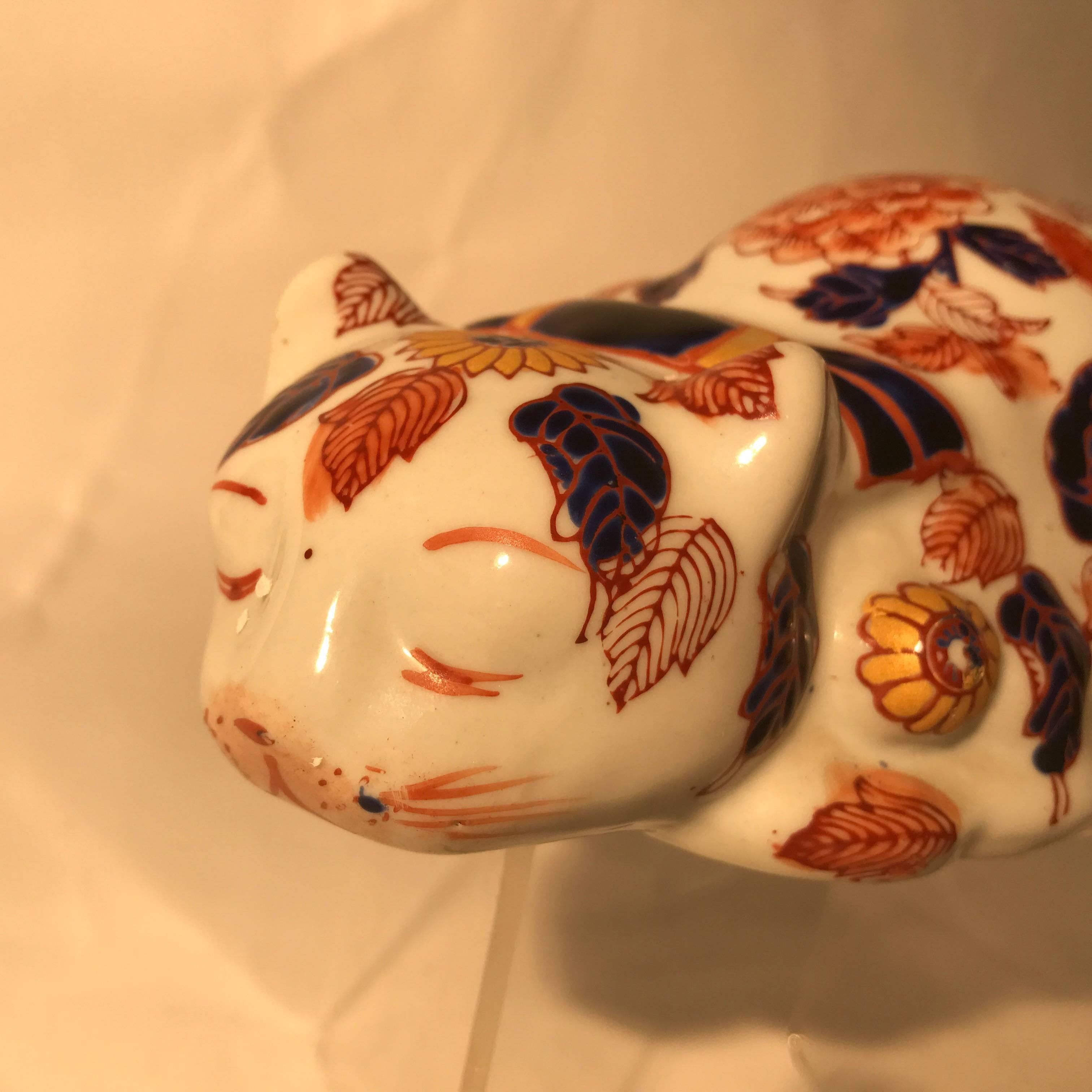 Japanese antique red enameled porcelain crouching cat, sculpture Okimono signed base, 1920.

Maker: Imari red enamels over blue, yellow, and green under glazing

Dimensions: 3 inches tall and 8 inches length

Large sculpture.
Hand