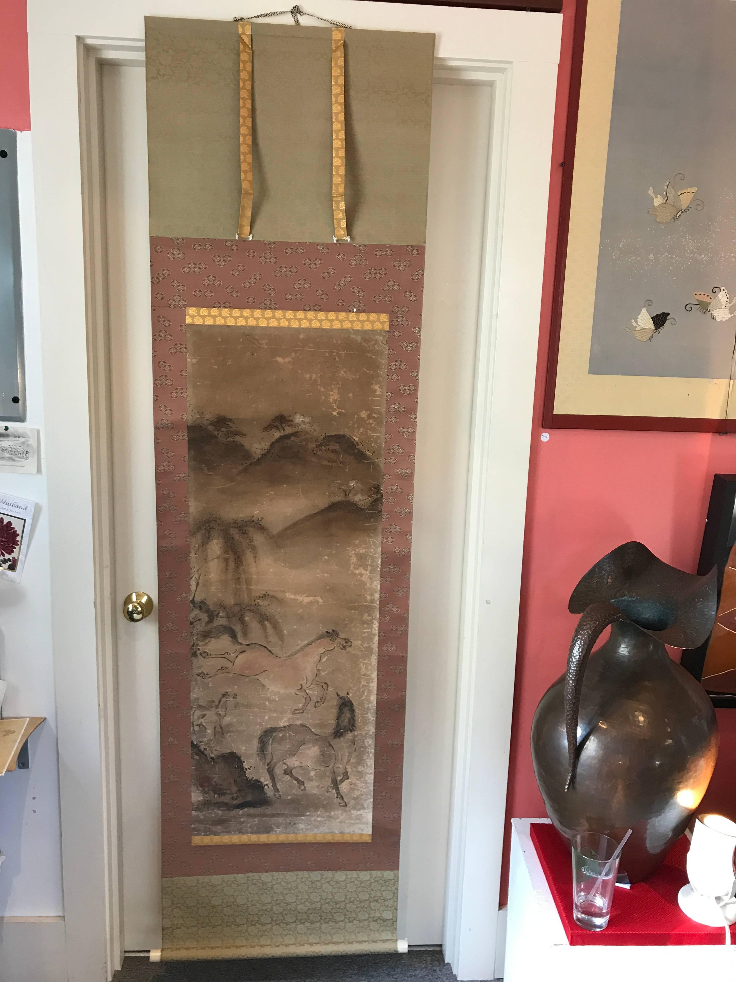 A Japanese Antique family of Galloping Horses on a mountainside 
Hand-painted scroll on paper.
Dimensions: 21.25 inches wide and 78 inches length
Hand written signed signature as photographed
Old bone rollers.

Japan, attractive composition of a