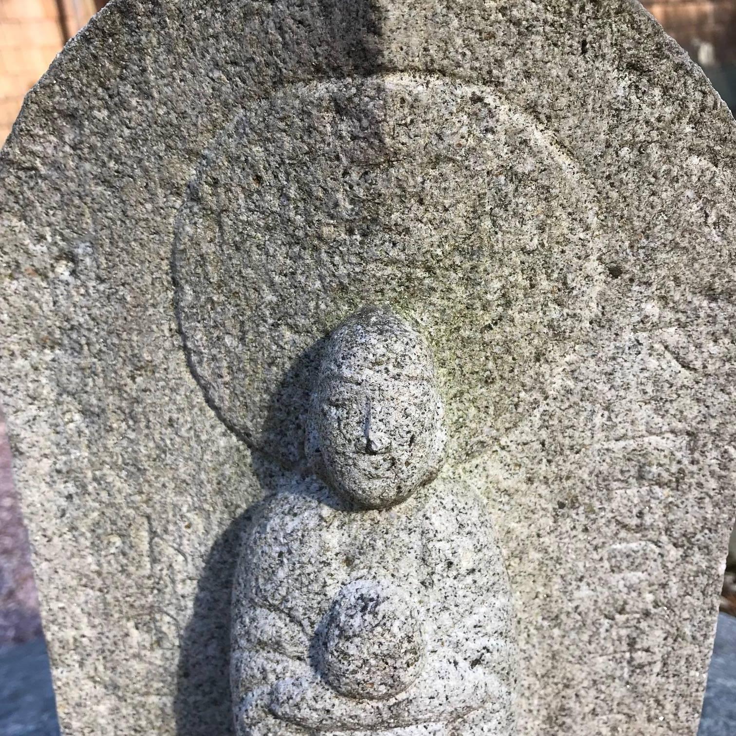 An uncommonly old Japanese Buddhist stone Jizo Bosatsu stands tall with well defined background mandorla and clutching his wish granting jewel or compassionate potion vessel. 

Sculpted from a gray-hued granite stone. Signed from the later Meiji