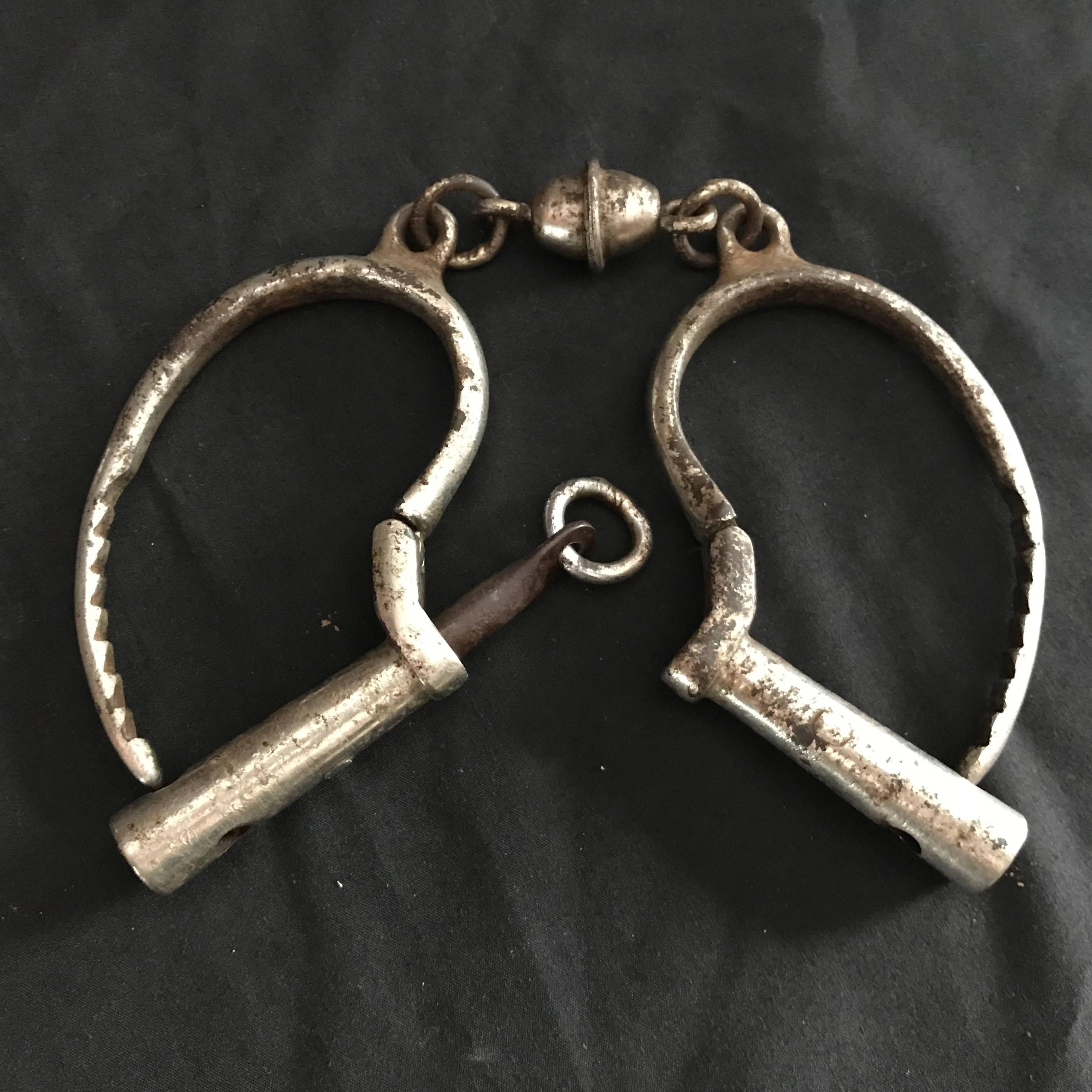 A hard to find Japanese antique pair of silver plated iron Samurai handcuffs dating to the 19th century, Meiji period. 

An unusual find.

This is a very fine Samurai pair complete with iron key.

Old patina and use appropriate to its great