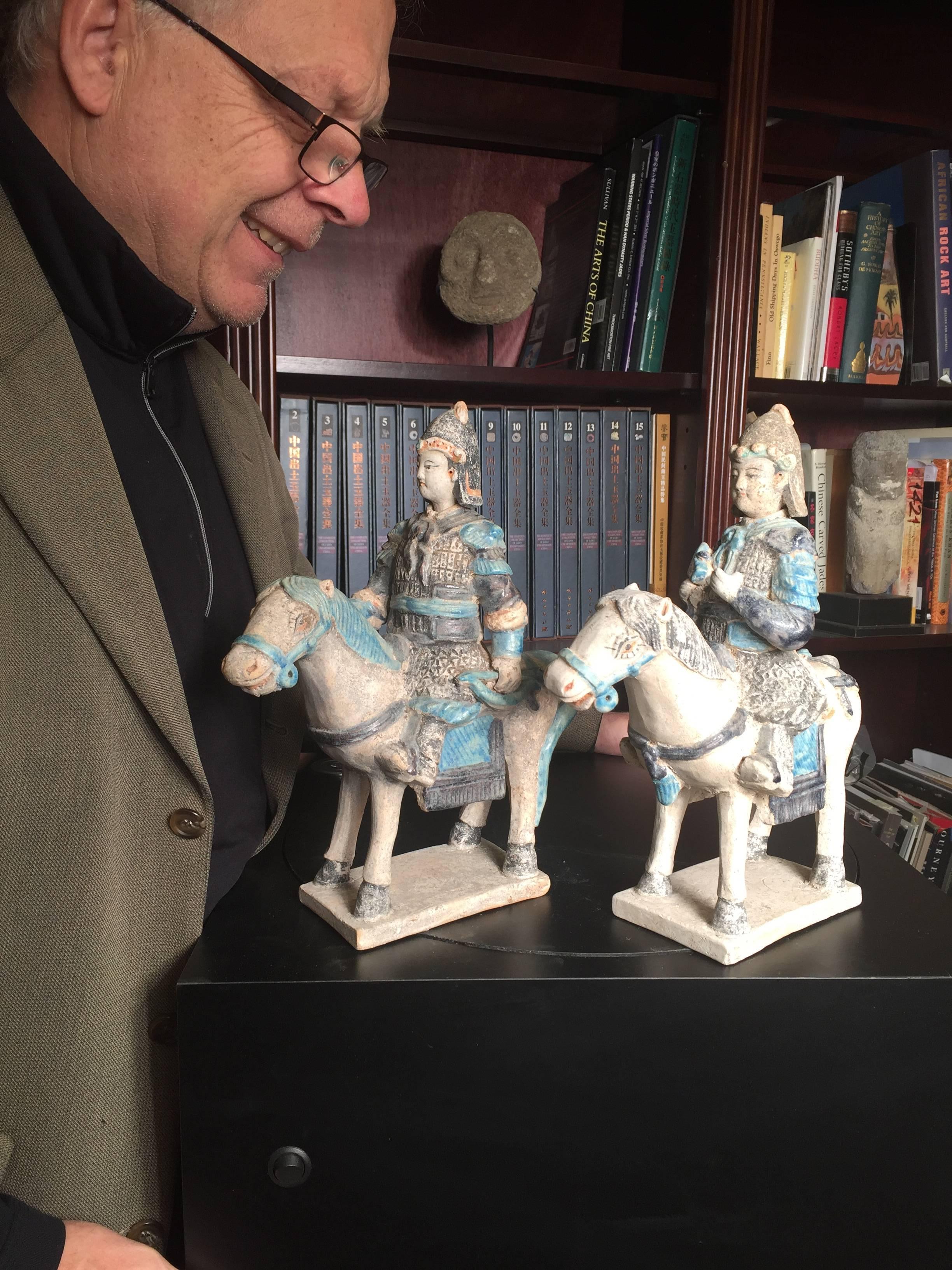 Important ancient Imperial China Ming pair of military horse riders brandishing an archery bow and battle ax, 1368-1644, each 12.5 inches in height. 

Crafted in stunning turquoise and cobalt blue color glazes. 

The men and their steeds are part of