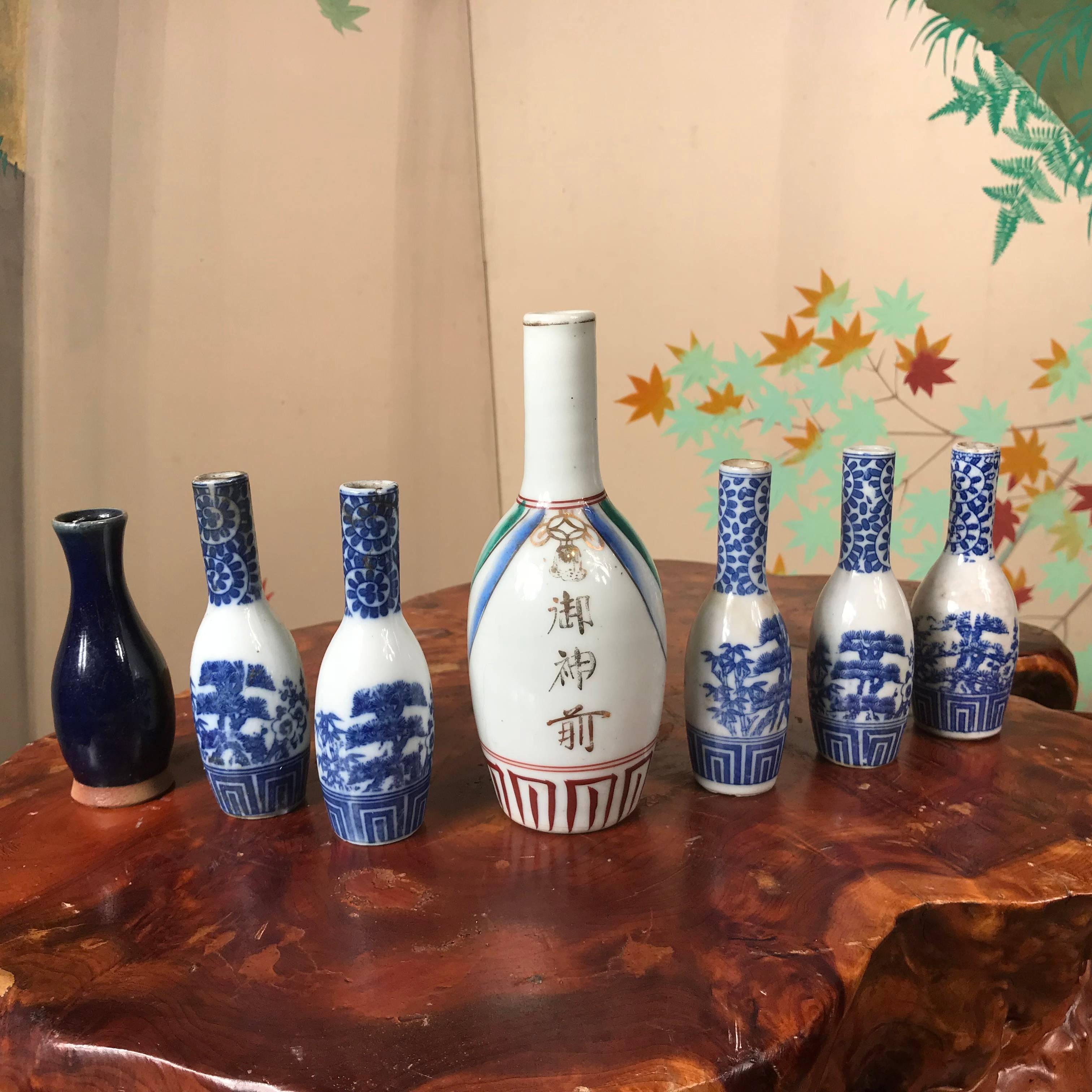 Japan, a collection of seven antique blue and white and iron red multi glazed porcelain sake bottles, Meiji period. These are beautiful little gems, hand-painted in Classic floral patterns from the Arita kilns. Very good condition. Make unique bud