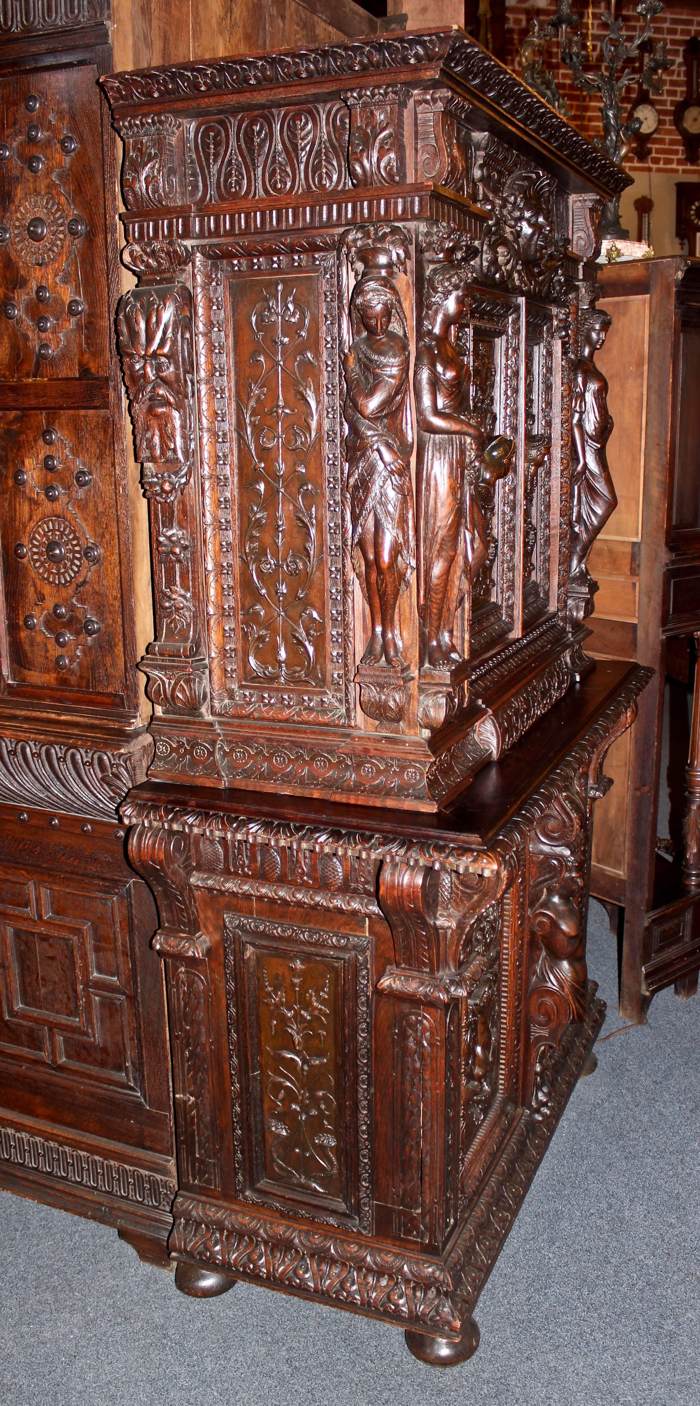 This French cabinet was hand-carved in the 1800s from walnut. It features hinge open doors on top, three pull-out drawers, and decorative, non-functioning doors on the bottom. Main panels are painted spelter. Inside was painted red after original
