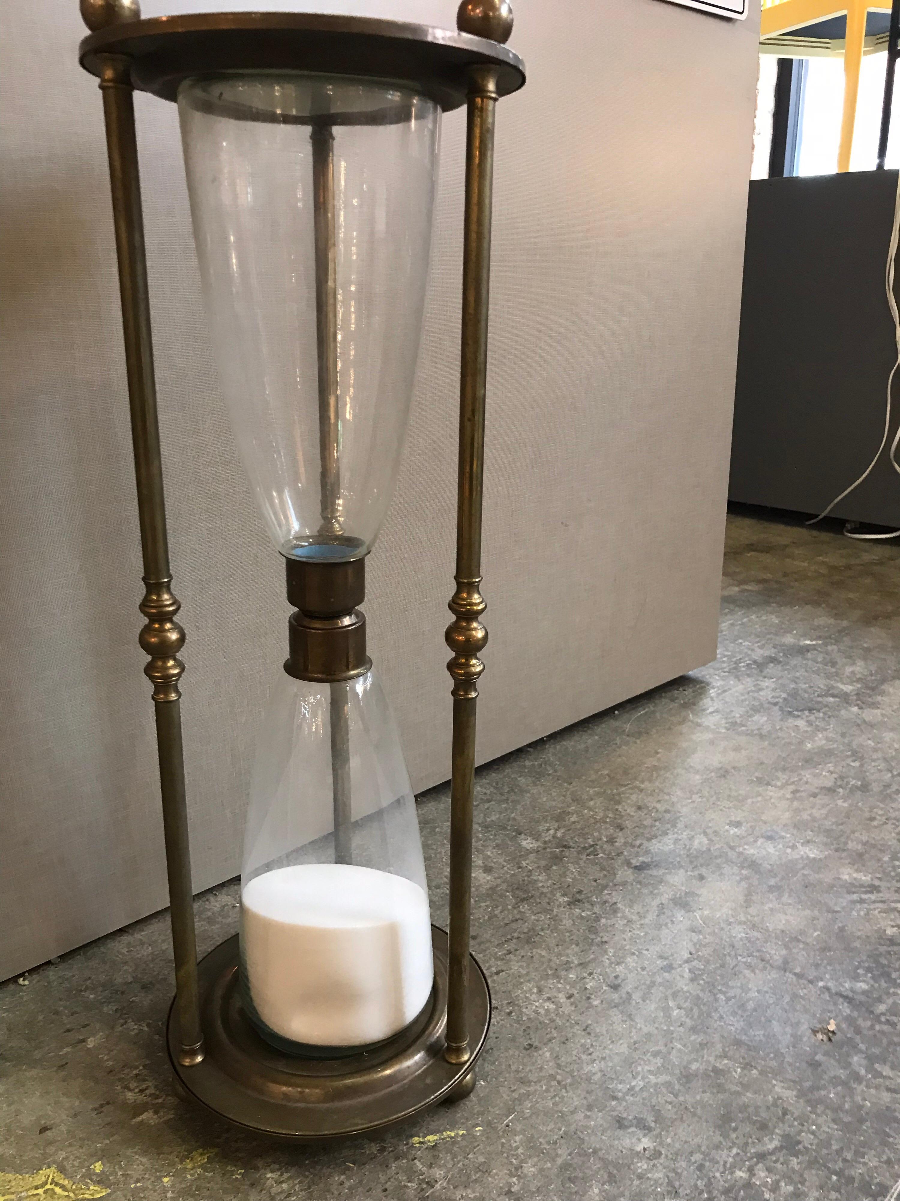 This is a vintage extra large brass and glass hourglass.