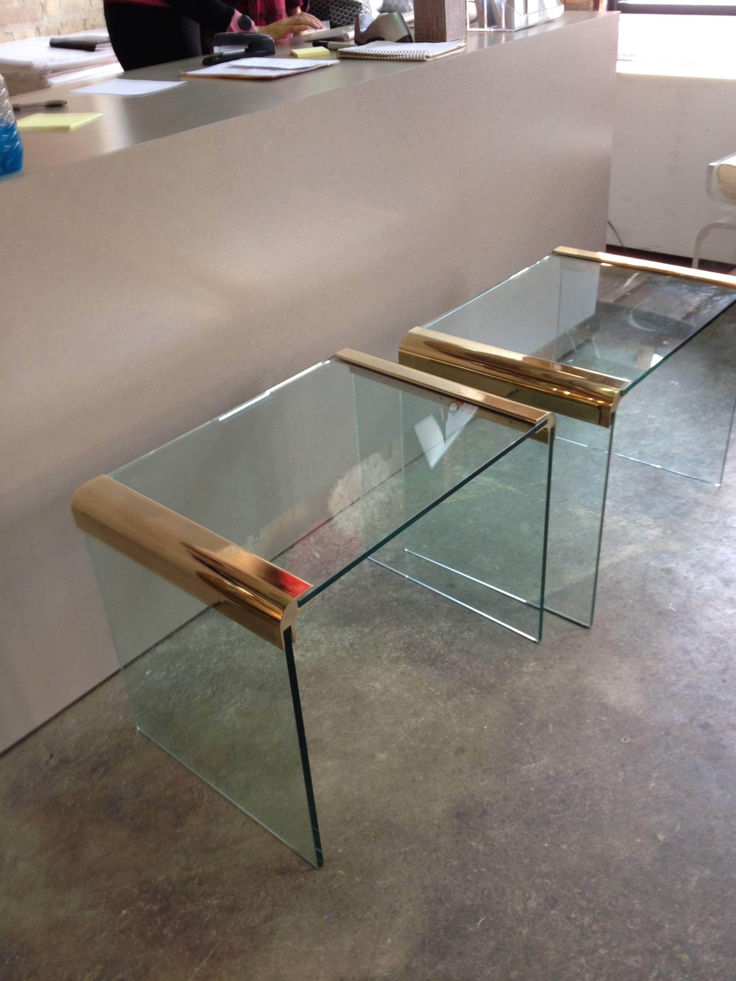 A pair of brass and glass end tables by Pace.