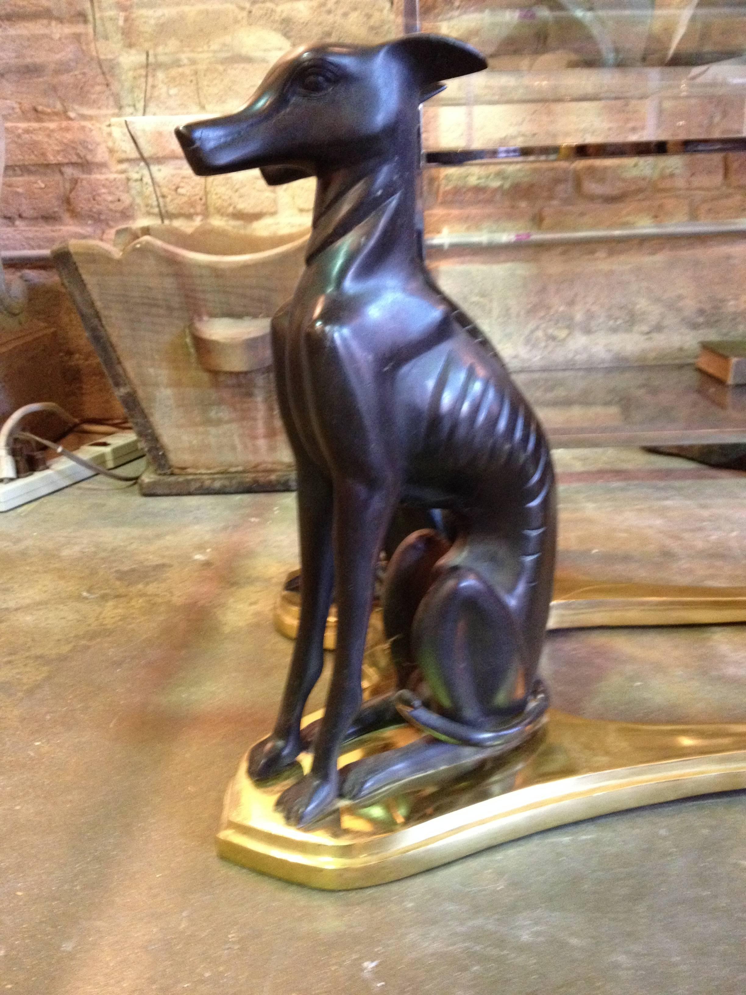 A glass top coffee table with a brass base and 4 whippet dog forms. base without glass is 28.5 X 16.0