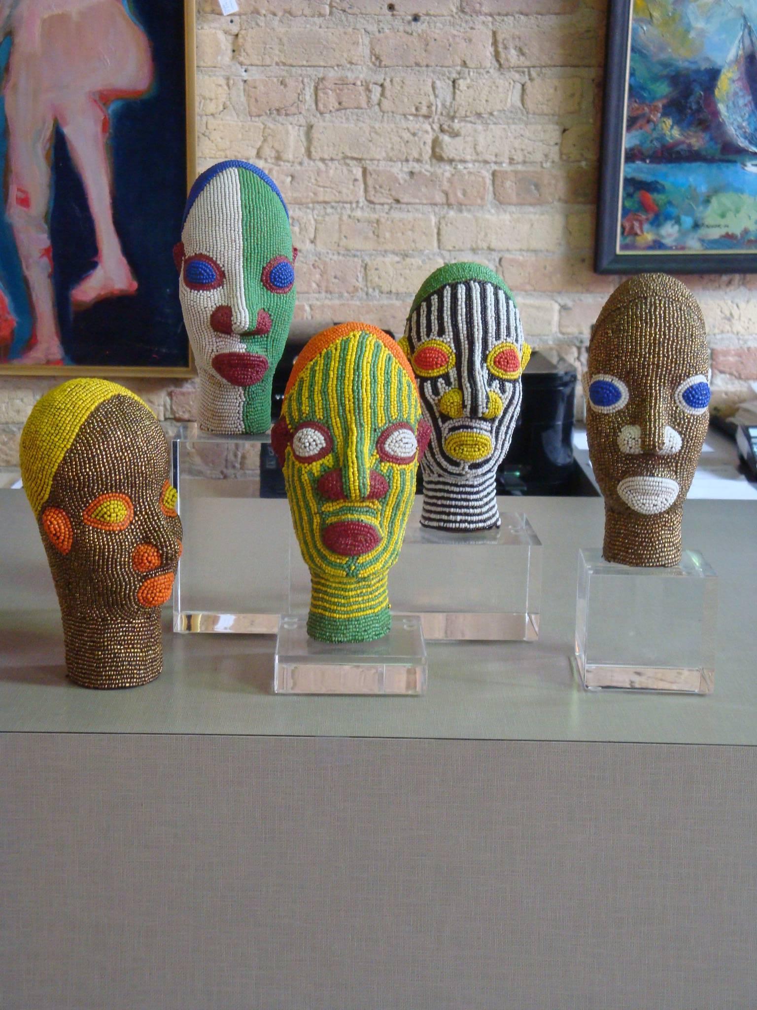 This is a set of five African beaded heads from Cameroon . Made of Clay and beads and put on removable Lucite stands They are all handmade.