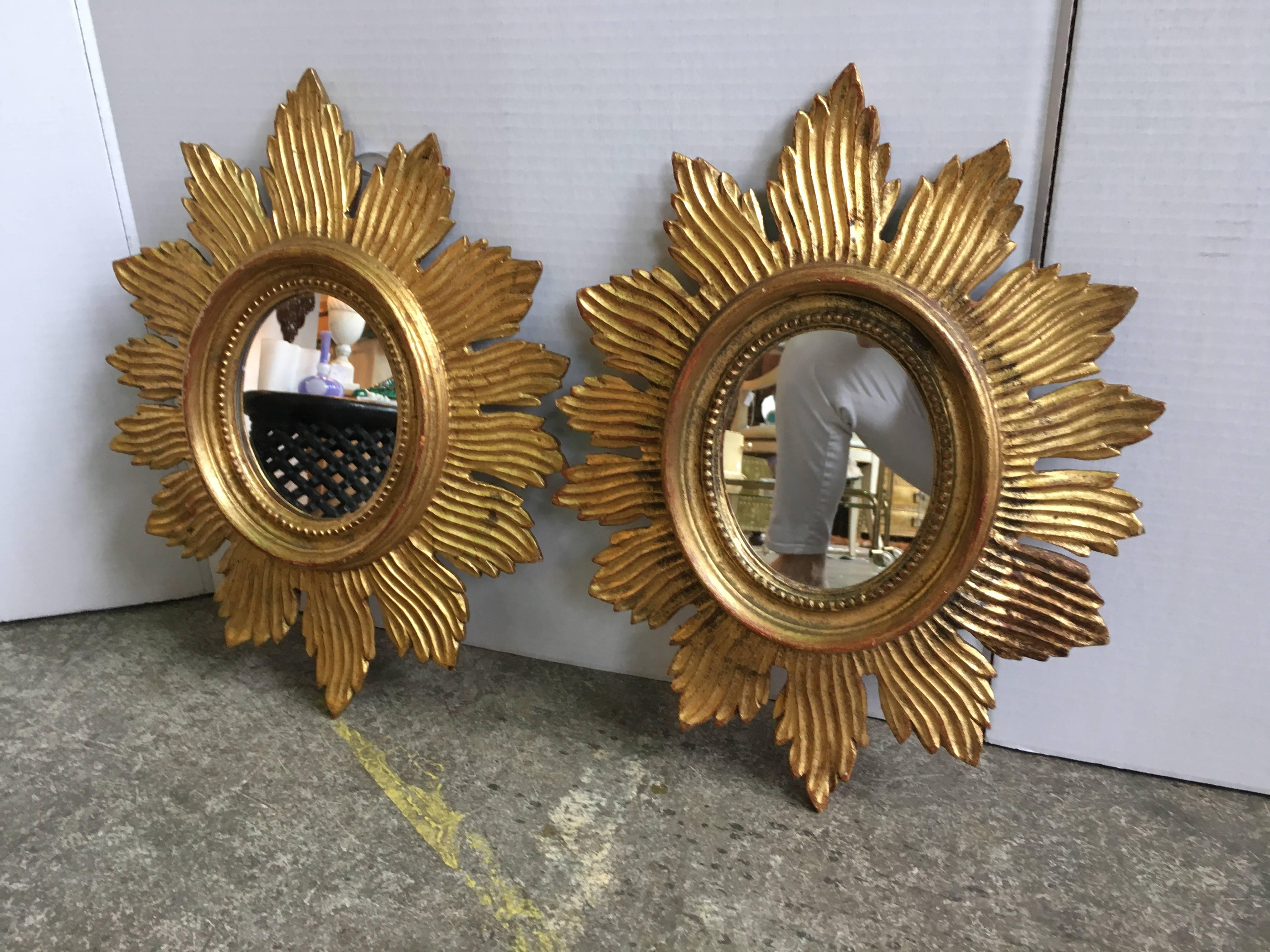 A pair of giltwood carved Palladio starburst mirrors.