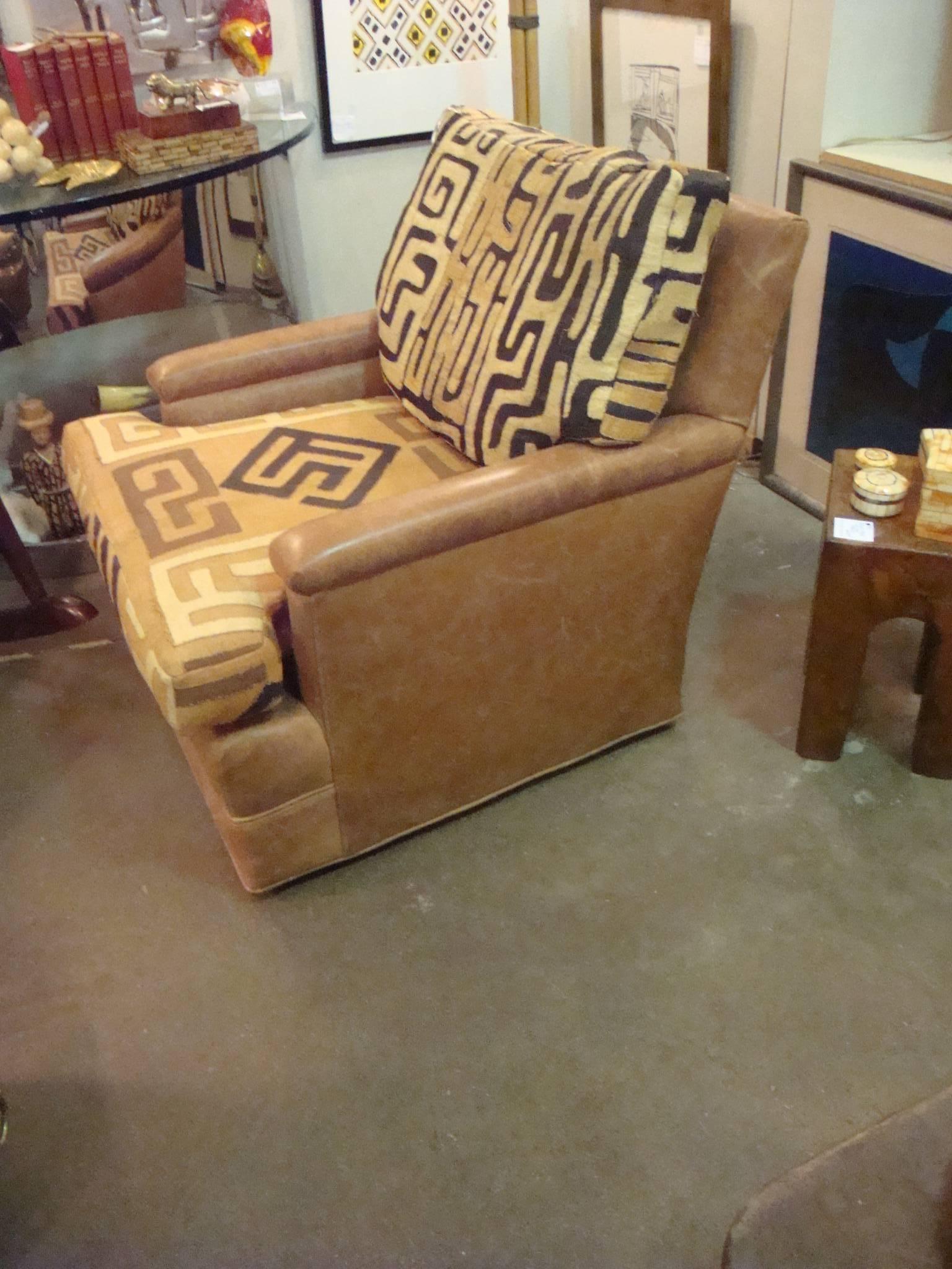 This is a vintage chair from 1960-1970s that has been recovered in vintage kuba cloth and leather.