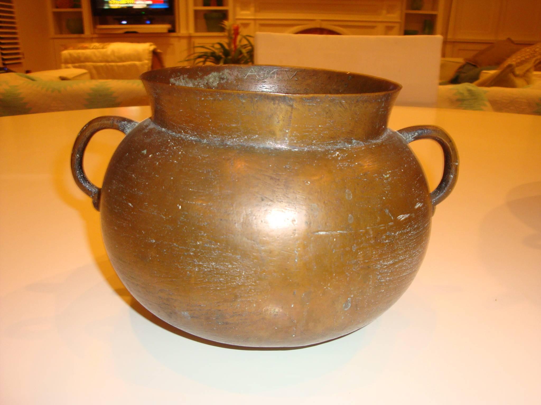 This is a set of four bronze artisan made 20th century pots. Each pot has initials inscribed on the neck .One pot has the name Legundo Gomes with a heart symbol next to it . They appear to be handmade.