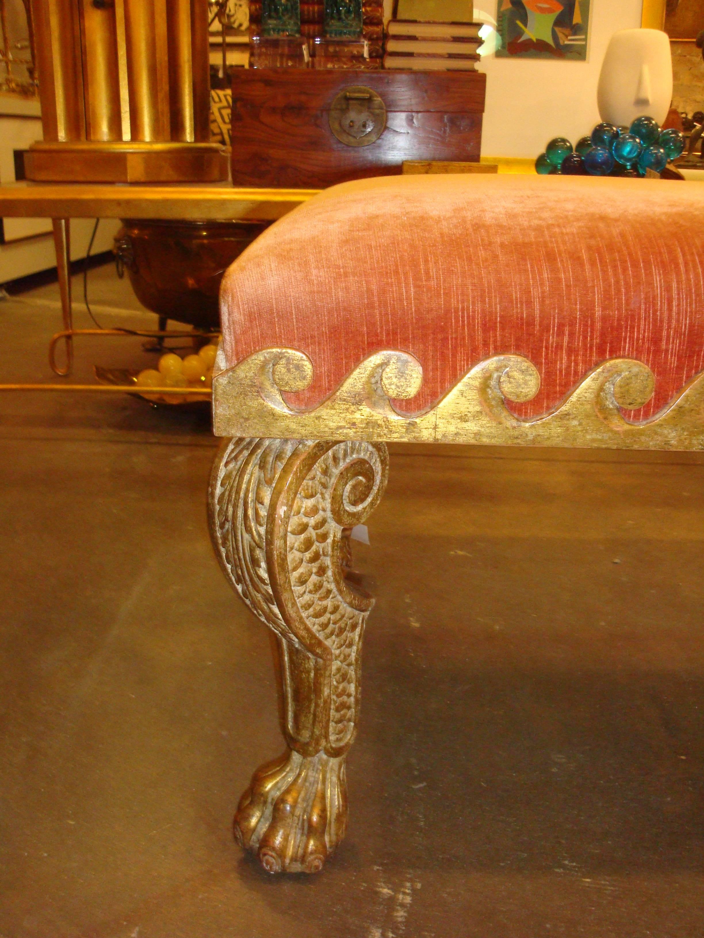 This is a giltwood scalloped bench with giltwood claw feet, covered in a coral colored velvet in 1990s.