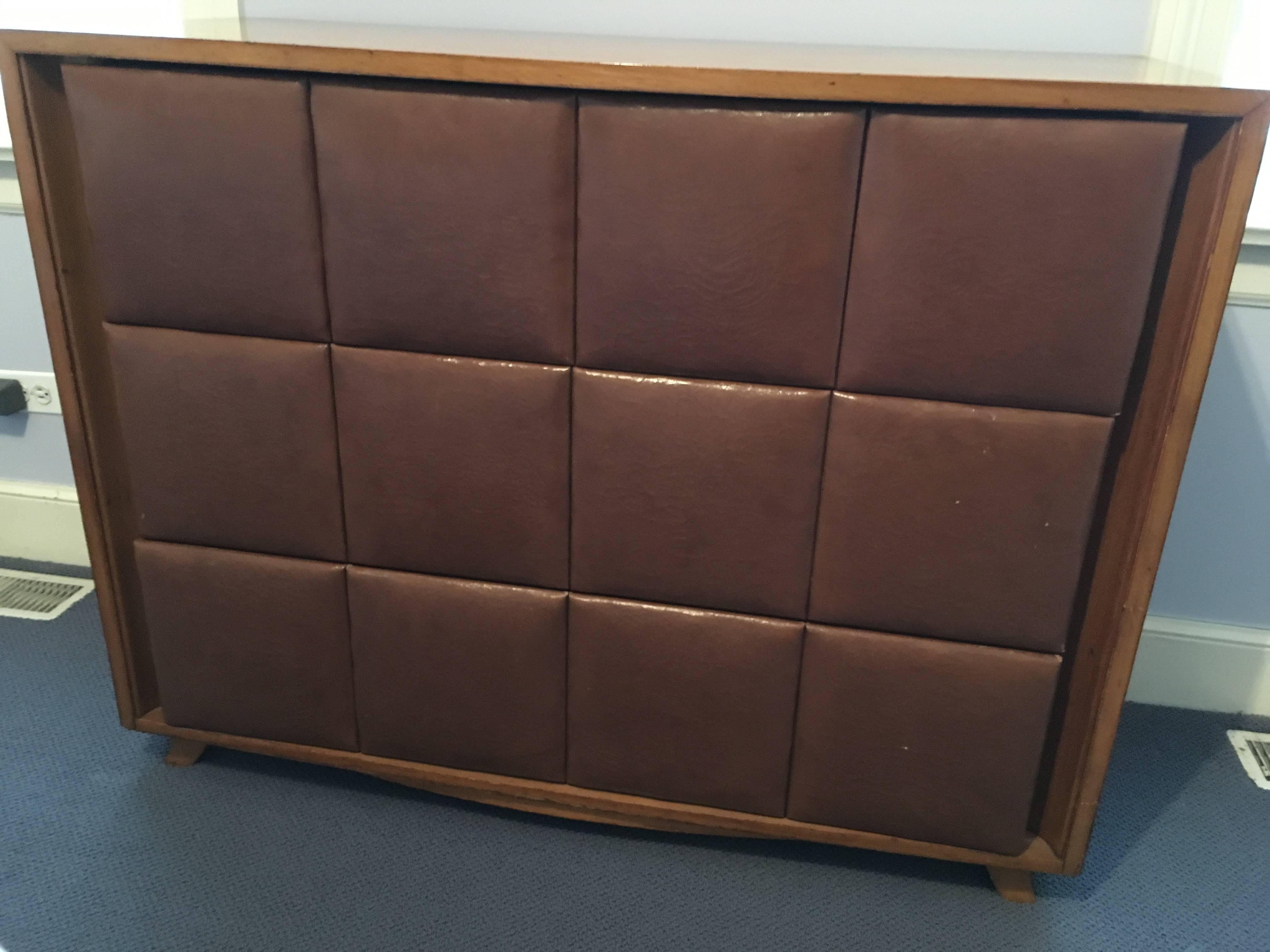 A Mid-Century bleached mahogany chest of drawers by Gilbert Rohde for Henry Miller with padded Naugahyde front.