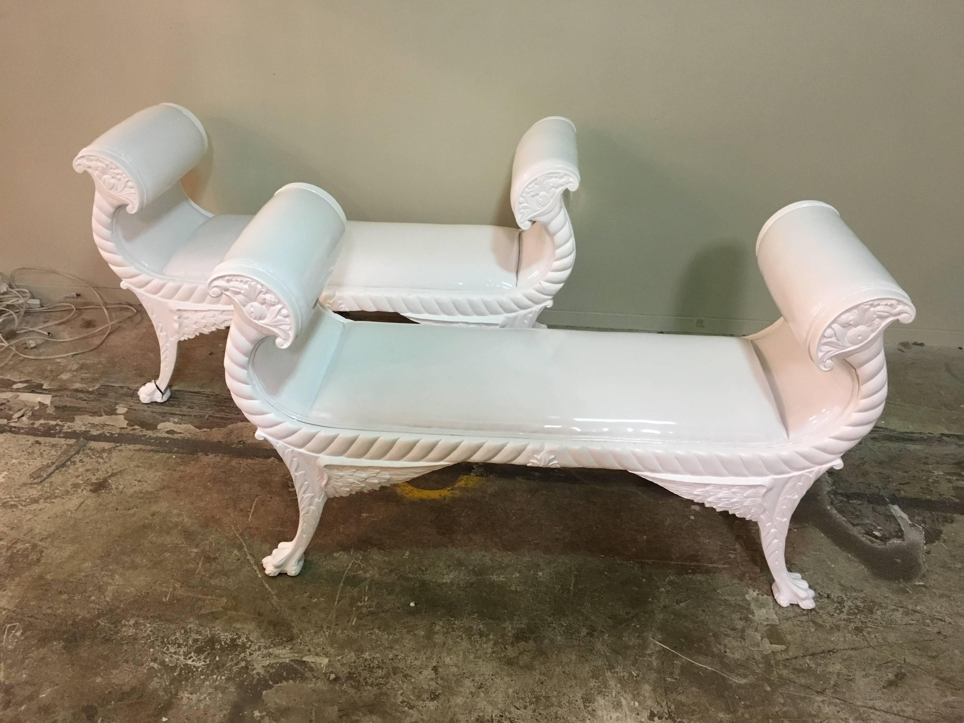 A pair of newly upholstered carved wood claw feet benches with rolled arms.