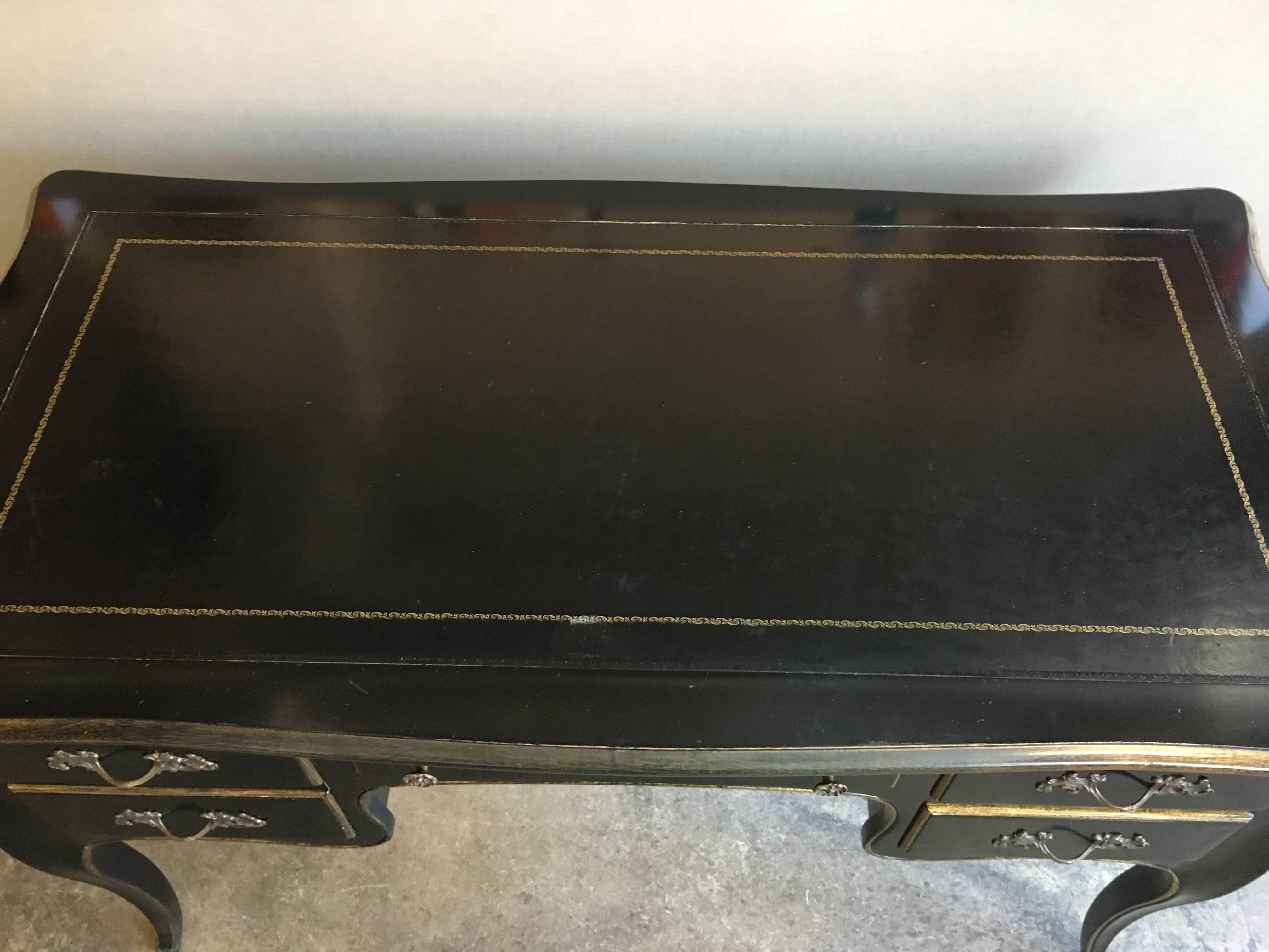 A Jacques Bodart black lacquered desk with leather tooled top. Desk has five drawers, contoured legs and brass pulls.