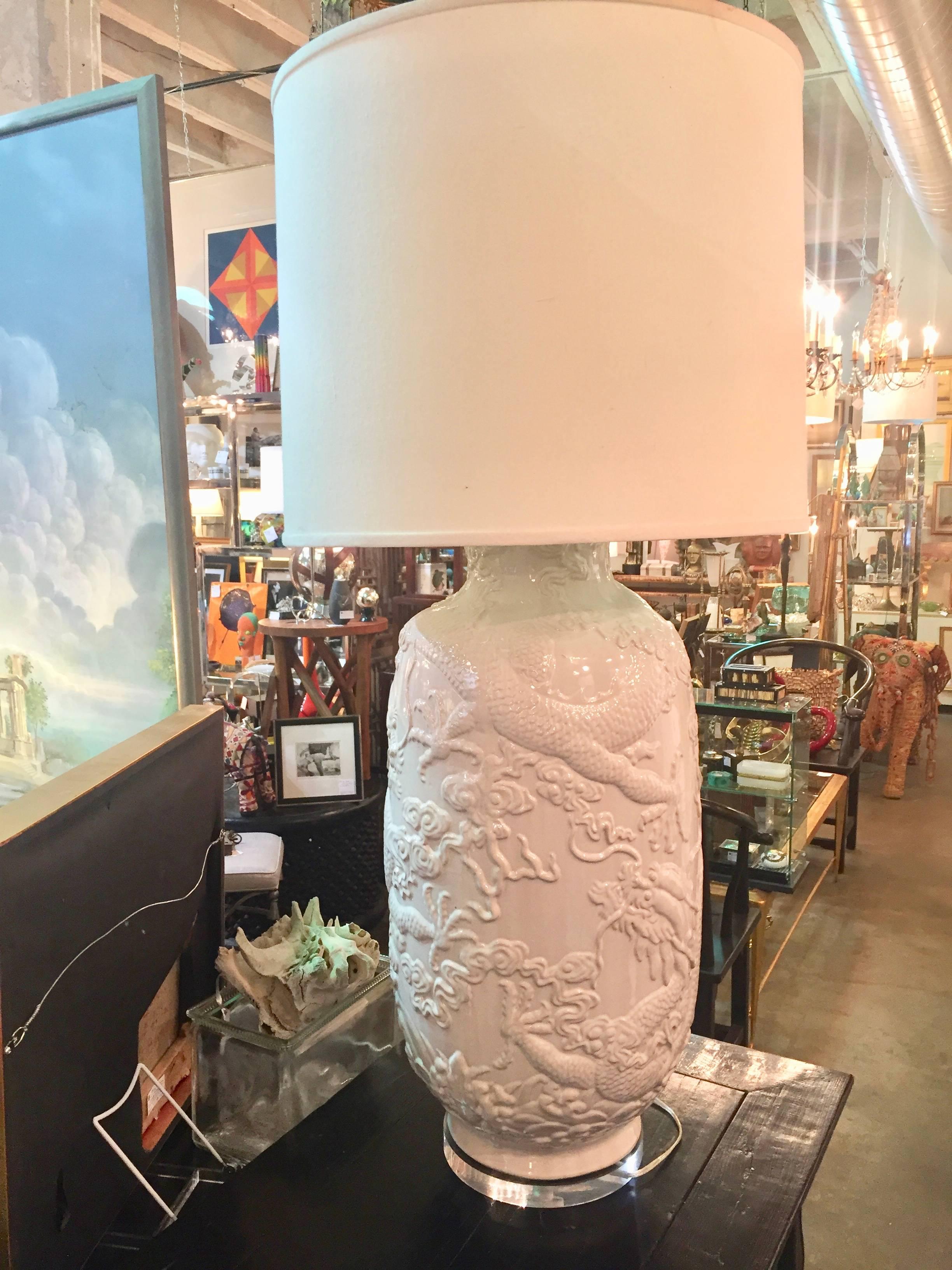 Impressive pair of Palace size white ceramic vases having raised figural snake and vine relief images now converted into table lamps. Without the shades they stand 27 inches tall.