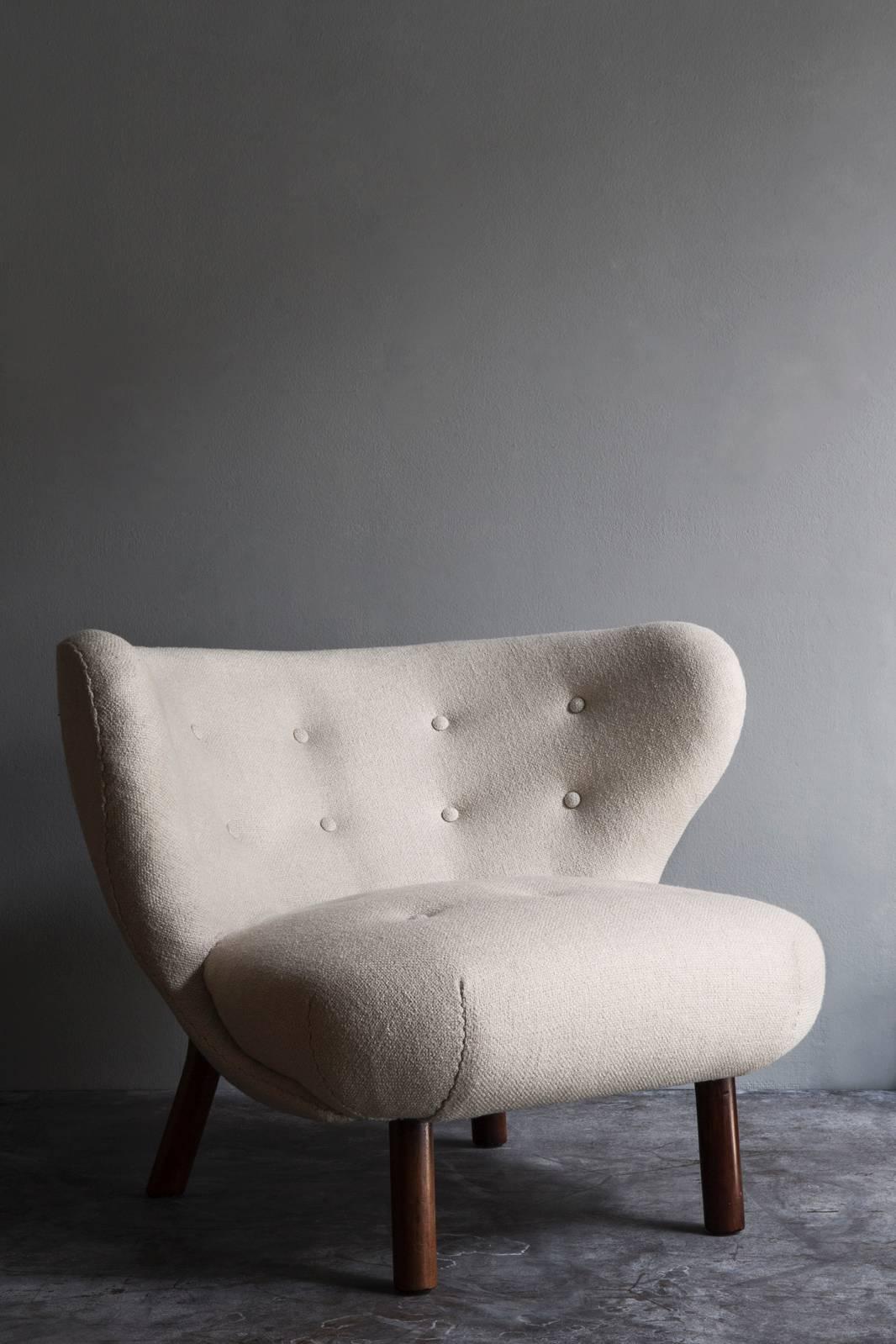 Easy chair, 'The Little Petra' designed by Viggo Boesen, made by cabinetmaker A. J. Iversen. Legs made of nutwood legs, seat and back upholstered with light wool fitted with buttons.
Please note - this item is located in our New York City Studio