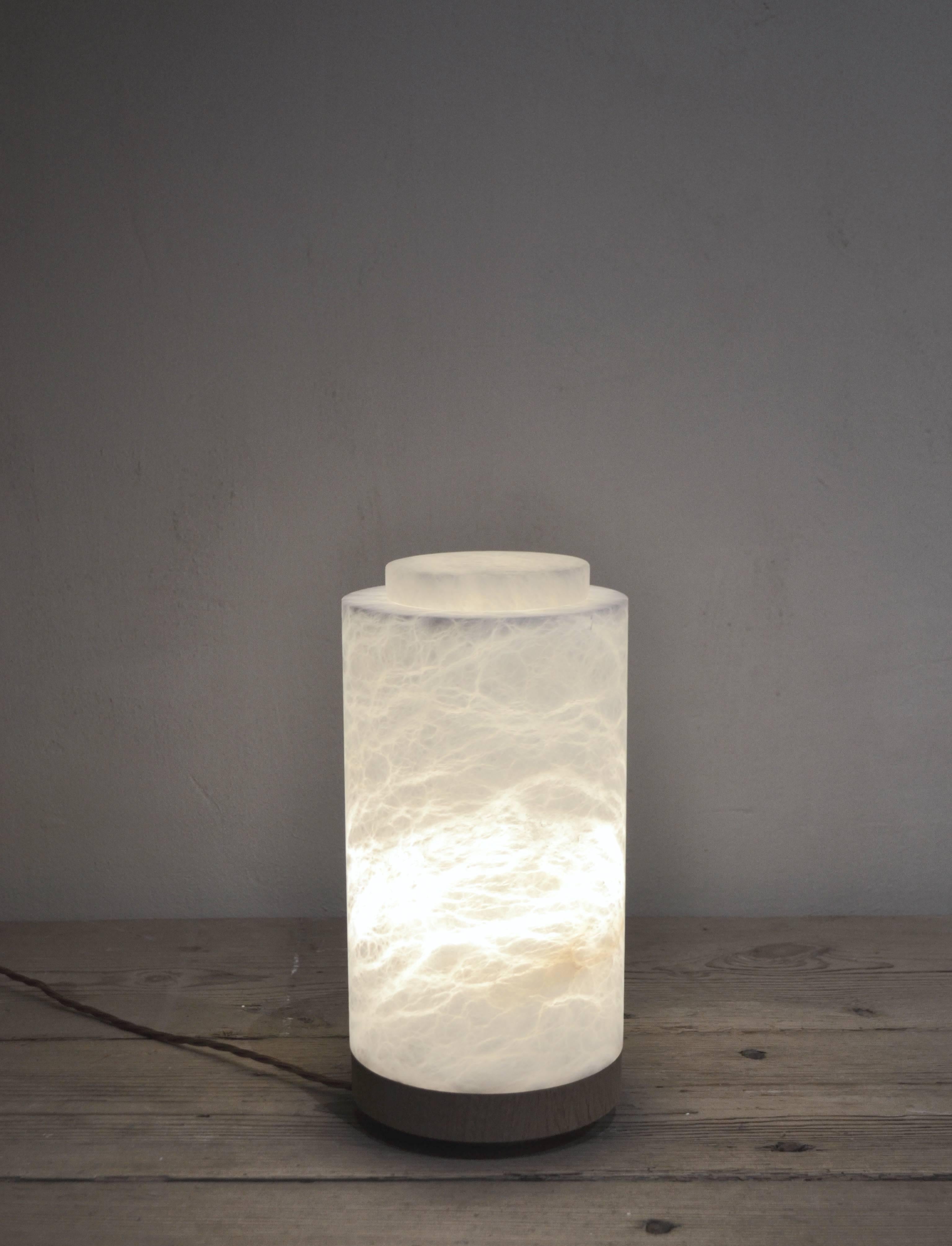 Alabaster lamp from Michaël Verheyden with removable alabaster top, base in natural solid oak. Old school plug, switch and twisted cable. The lamp has a warm and soft glow.