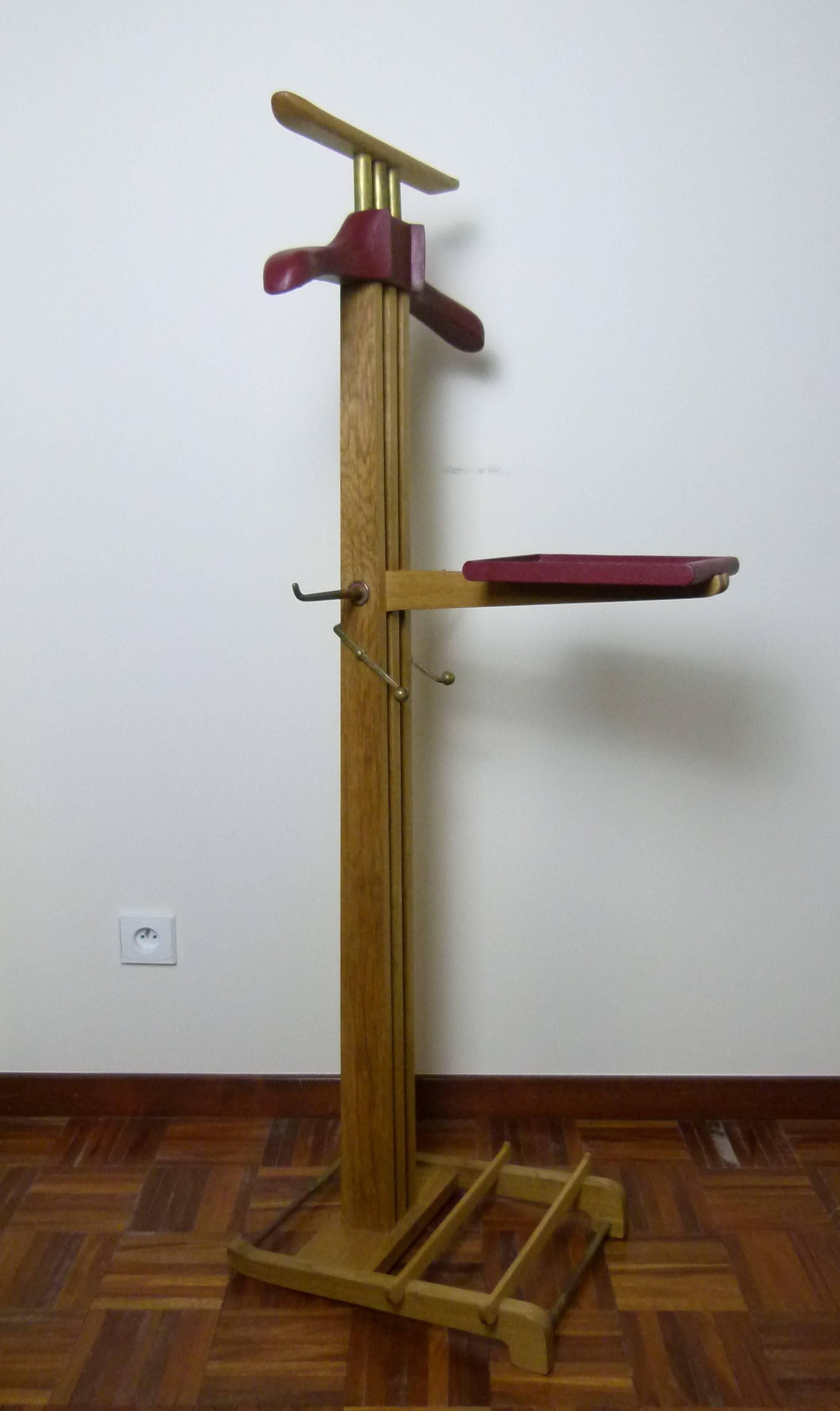 Solid oak and red leather-wrapped cloth valet, with a coat hanger and a folding table wrapped with red leather by Hermès.

Tie holders and shelf mechanism in gilded bronze.
1940s French work of Paul Dupré-Lafon for Hermès.
Furniture listed in
