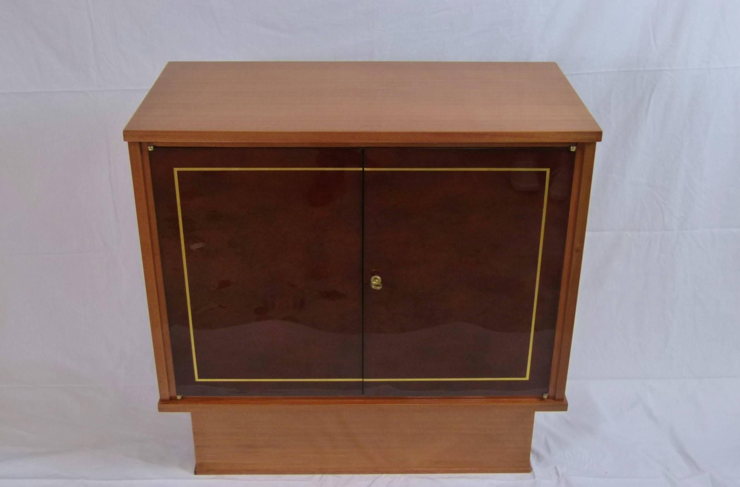 Pair of cabinets or commode, consisting of a rectangular frame in blond varnished mahogany mounted on a detached base in blond mahogany opening in the front by two doors in beaked Beka lacquer on a row of shelves in sycamore.
A leaf decor highlights