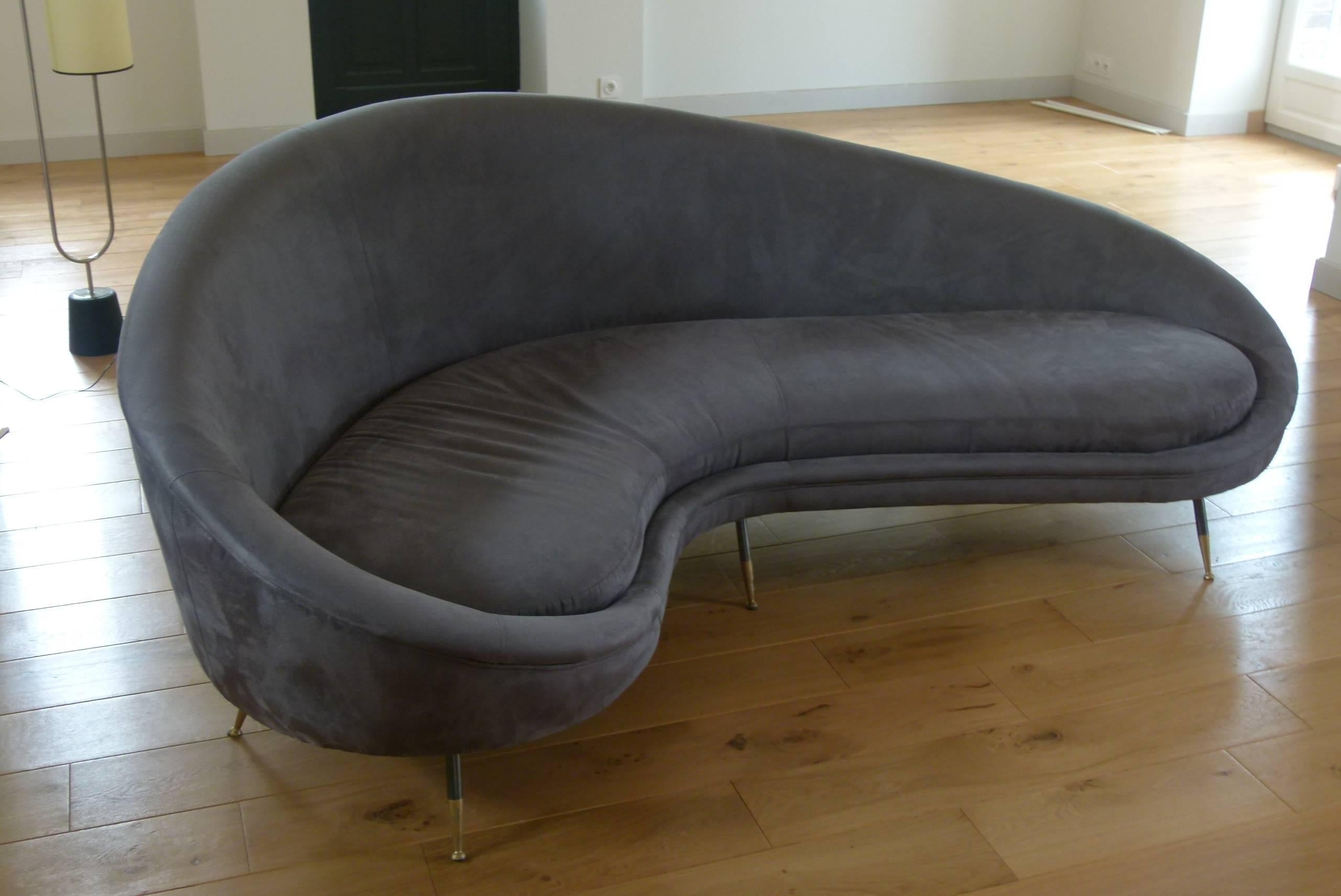 Sofa so-called bean or free "shape" consisting of a wooden structure covered with grey deer buckskin like fabric. Seat cushion fixed on the sofa. Fabric is set with a braid.
It rests on six tapered grey gun color and gild finish metal