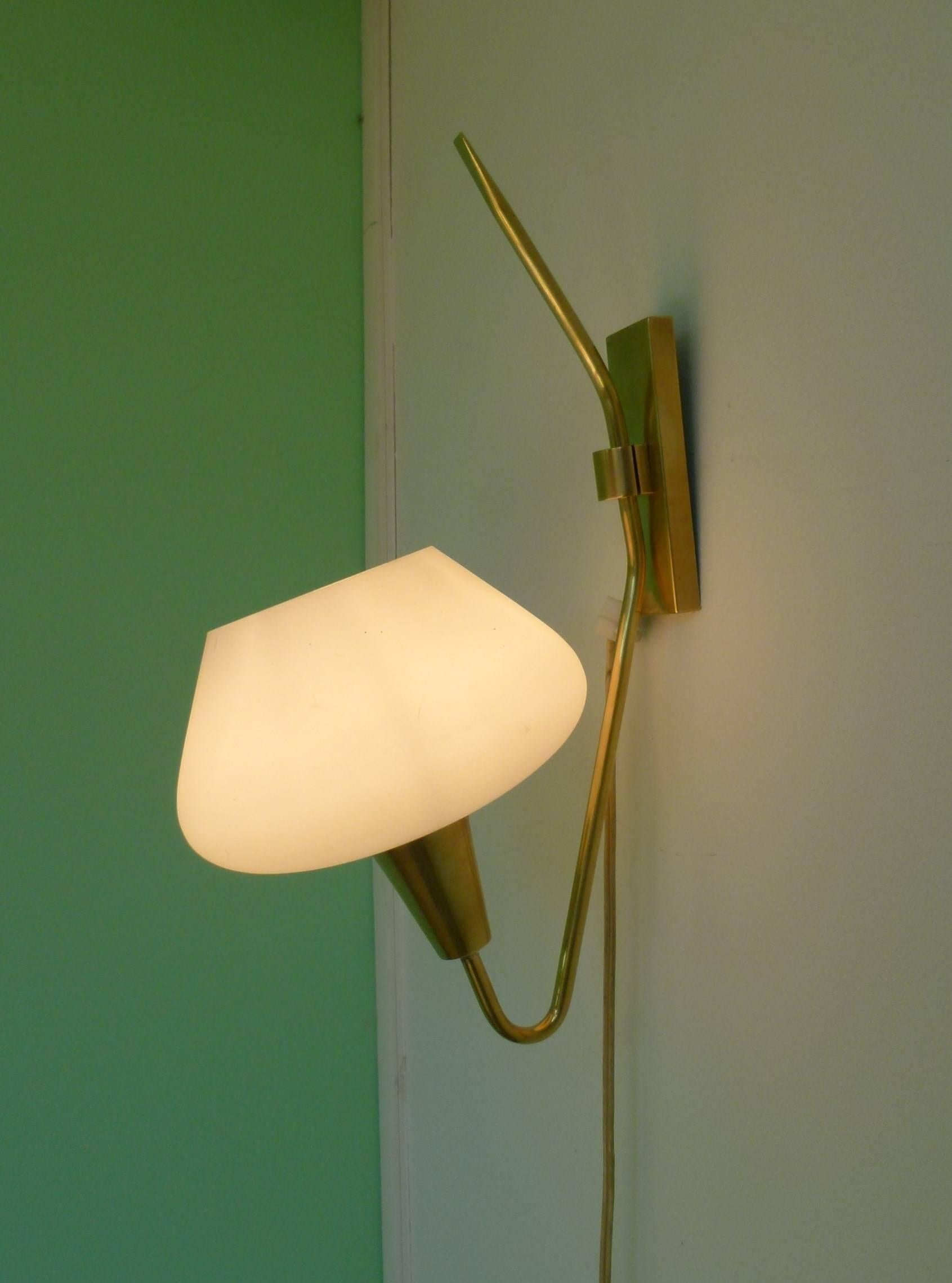 Pair of brass and opaline glass sconces consisting of a rectangular brass base on which is set a brass lighted arm ending with a conical support surmounted by a white flared opaline glass lampshade.
New wiring to the EU standard.
1950s French work