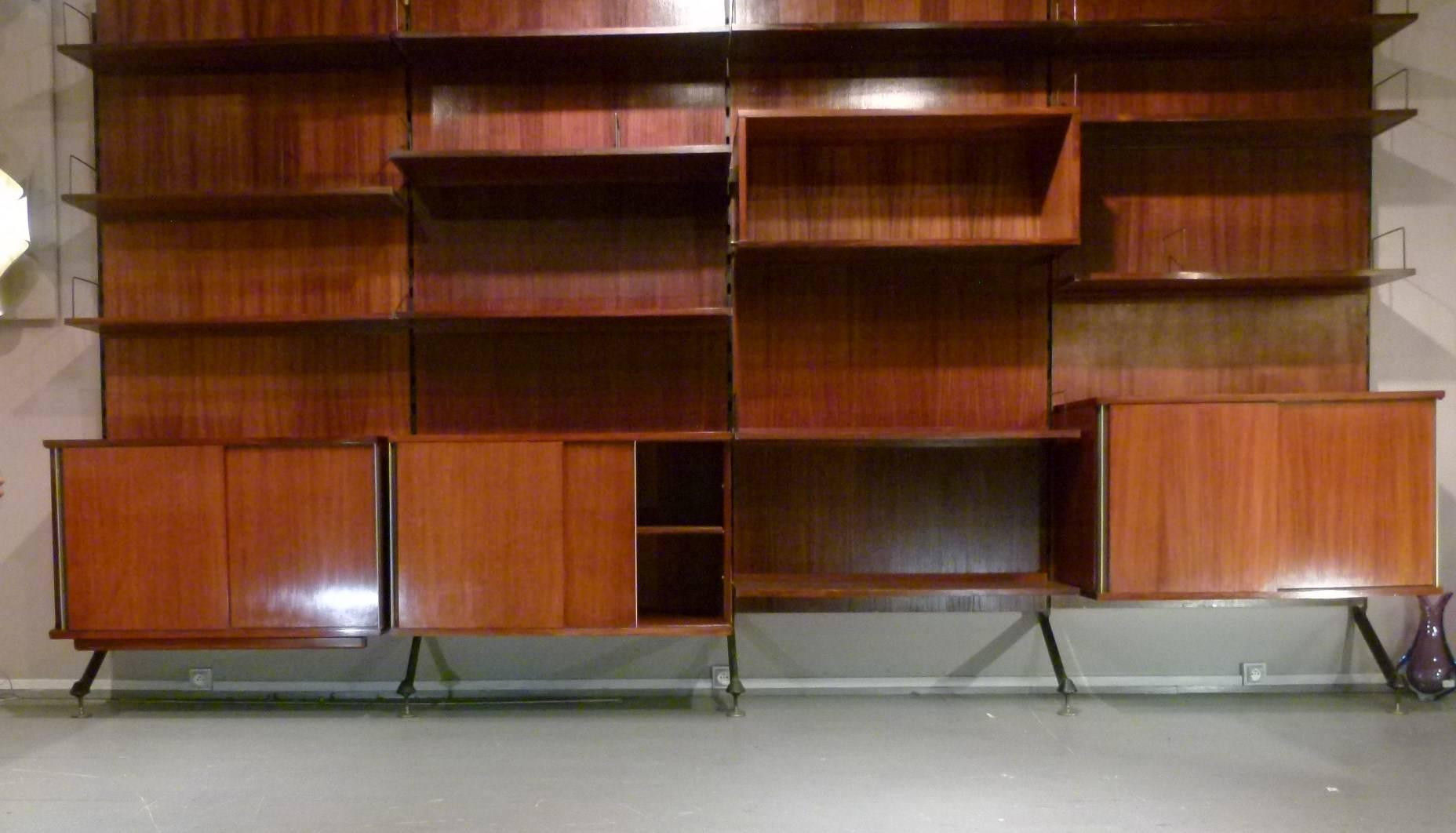 Rosewood and metal bookcase composed of four rosewood pedestals with bookshelves and bookends.
The boxes open with two sliding doors on a row of shelves.
Each box measures 95 cm wide with a total of 380 cm.
The bookcase is mounted on metal racks