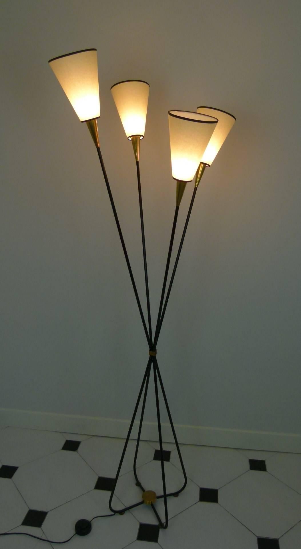 Floor lamp in black lacquered metal and brass consisting of four free-form arms in black lacquered metal.
The arms are tightened at the centre and are surrounded by a cord of brass.
They go upwards and open outwards and are terminated by brass
