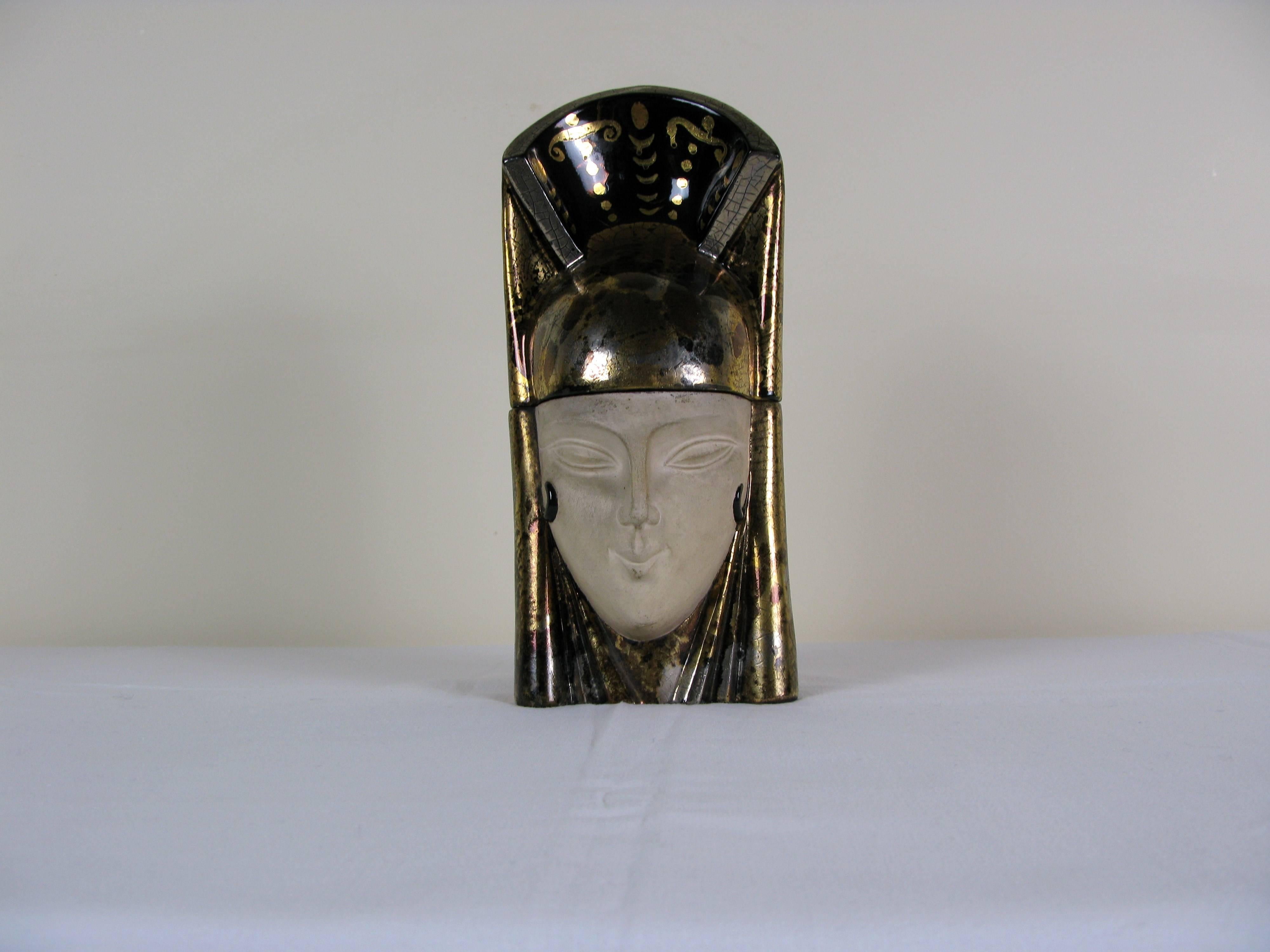 Gold leaf candy box representing an Egyptian head in enameled earthenware.
French Art Deco work by ROBJ.
Signed and numbered (6 on 9) under the base.
Perfect original condition.