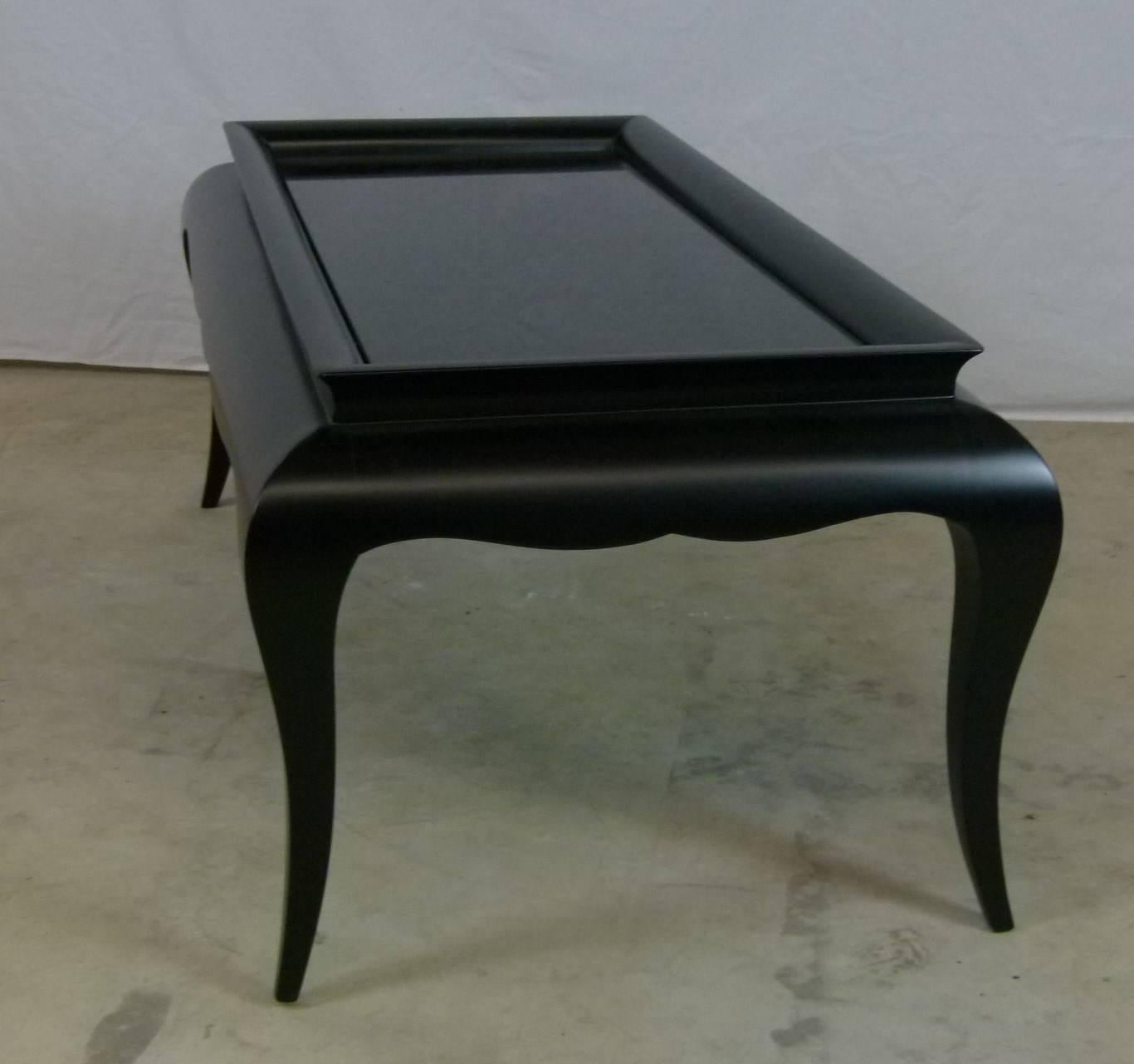 Coffee table, in satin black lacquer, composed of a black glass opal plate, framed by a black lacquered wooden frame.
The set rests on four black lacquered saber feet.
This table has been completely restored and re-lacquered, the glass slab is
