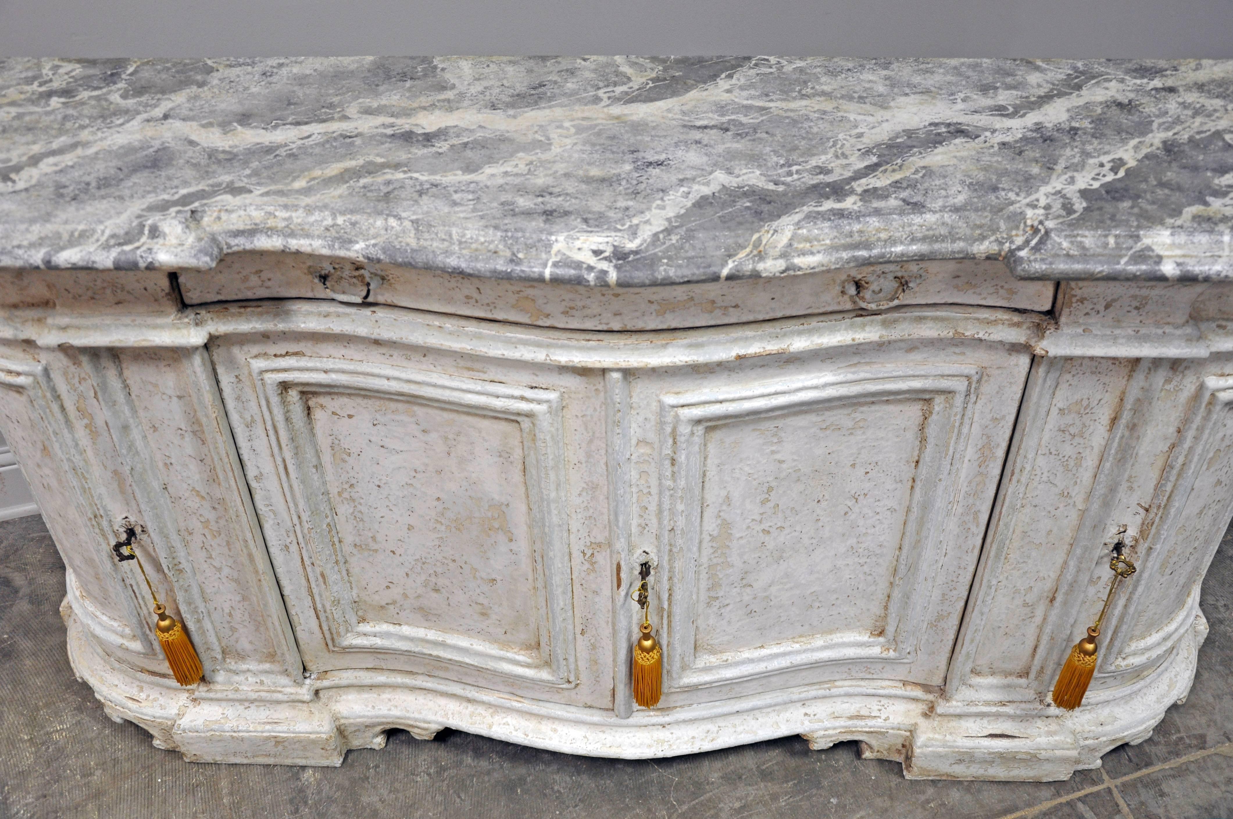 Classic Italian credenza with decorative bracket feet and layered paint finish. Top is also painted in a faux marble finish and features a serpentine front. 

Established in 1979, Joyce Horn Antiques, ltd. continues its 36 year tradition of being