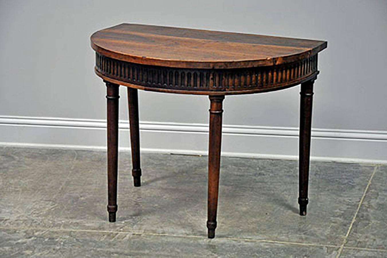 Single, handsomely-finished Louis XVI style demilune in walnut. Beautiful patina lends warmth to the clean lines expressed in the tapered legs and fluting details of the apron. 

Established in 1979, Joyce Horn Antiques, ltd. continues its 38 year