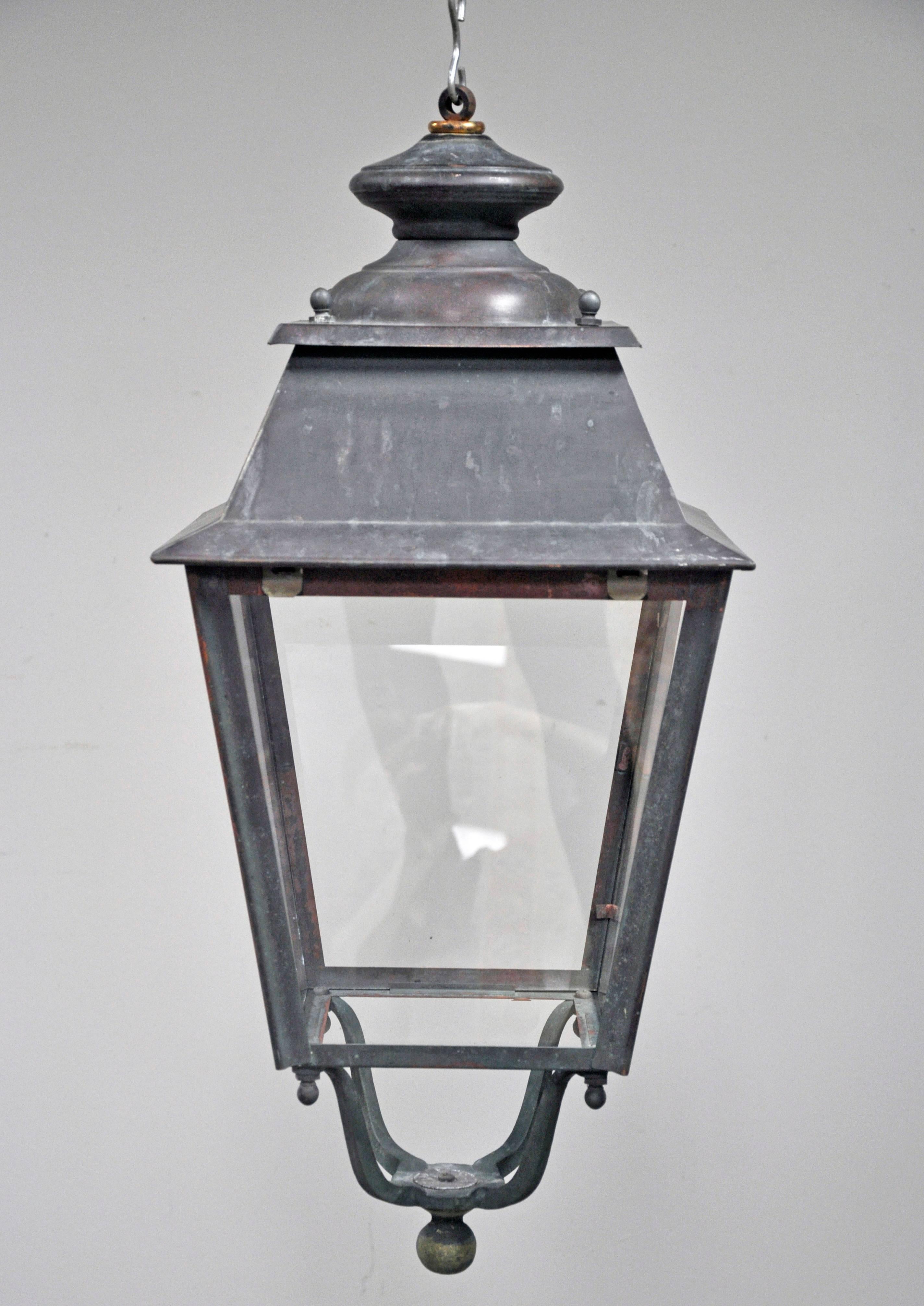 Well-scaled vintage single French porch lantern. Beautifully patinated copper and iron frame four tapered glass sides with visible areas of verdigris. Ball shaped finials decorate each of the four corners and are repeated at X-shaped base while also