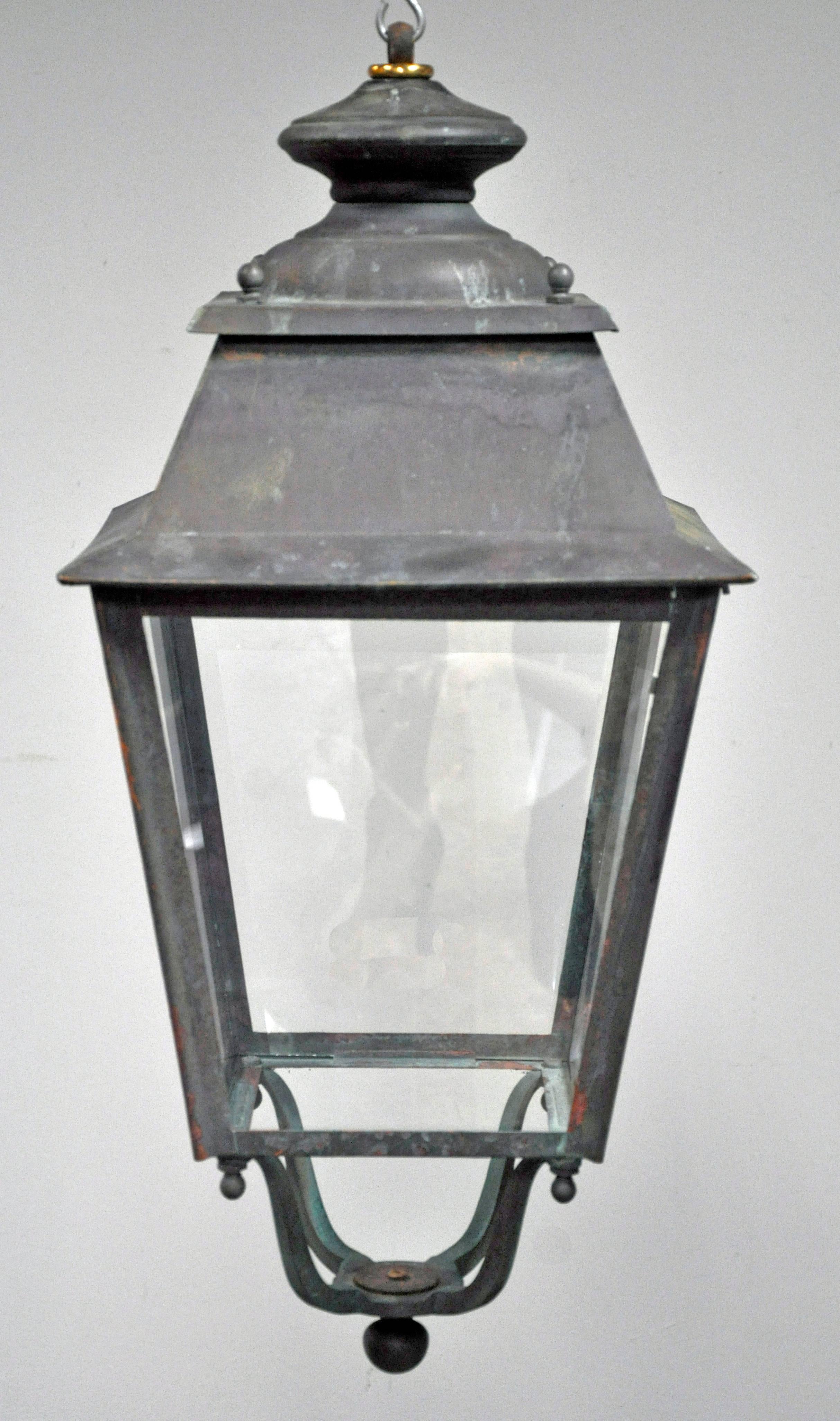 Well-scaled vintage single French porch lantern. Beautifully patinated copper and iron frame four tapered glass sides with visible areas of verdigris. Ball shaped finials decorate each of the four corners and are repeated at x shaped base while also