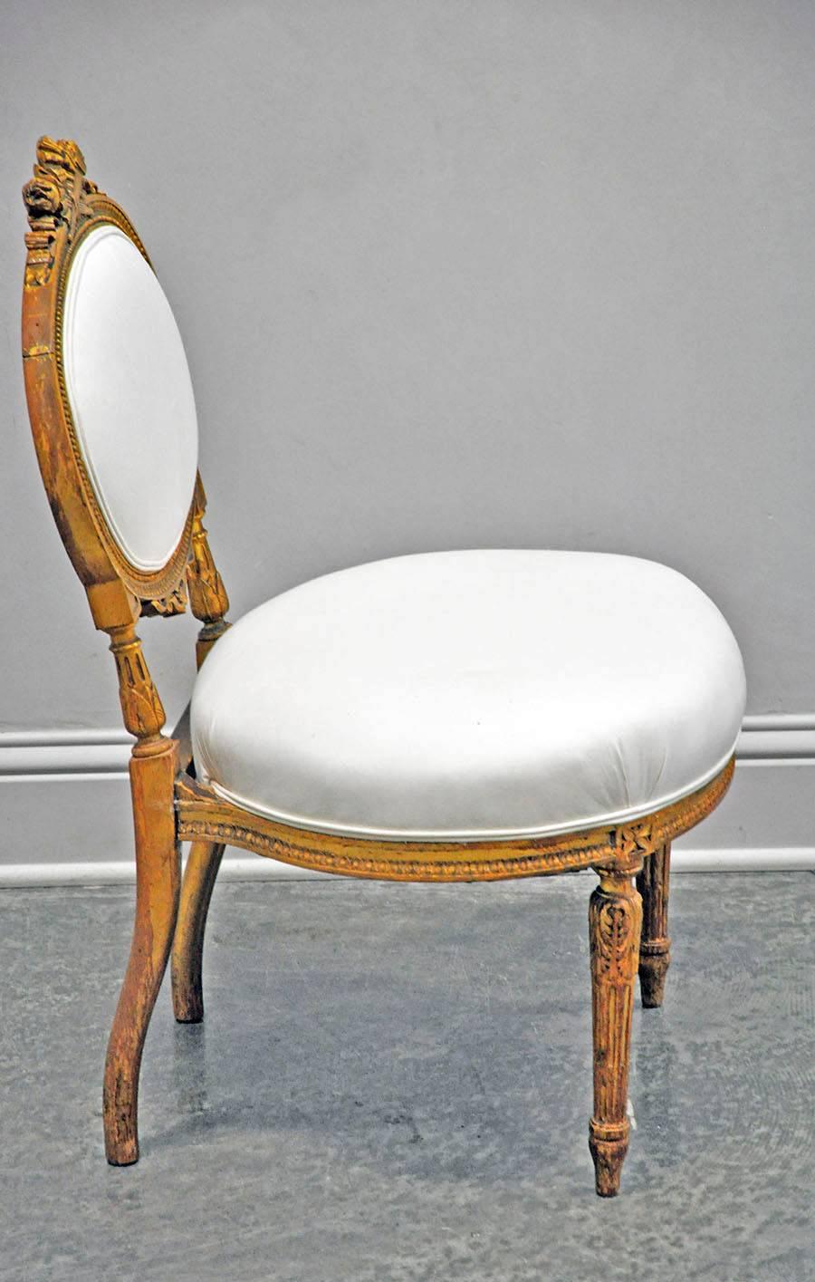 Petite and charming Louis XVI style chauffeuse or fireside chair with gold gilt and upholstered in muslin. Carved bow and fluting details make this a beautiful addition to any space.

Established in 1979, Joyce Horn Antiques, ltd. continues its 38